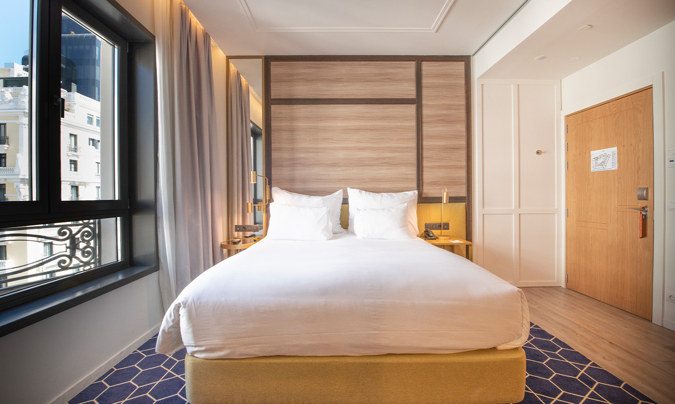 El Premium con Vista del Pestana CR7 Gran Vía Madrid tiene cama doble y ventana grande con vista a los edificios enfrente