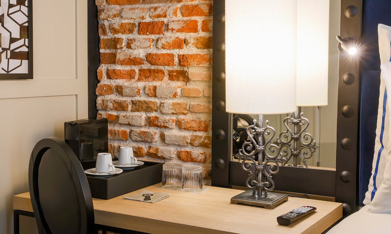 Habitación Superior del Pestana Plaza Mayor Madrid con escritorio silla espejo y máquina de café Nespresso