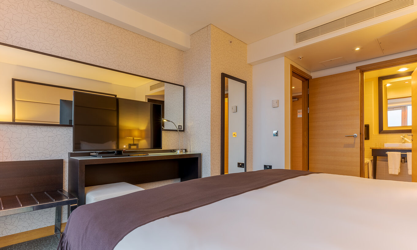 La Executive One Bedroom Suite del Pestana Chelsea Bridge tiene cama doble, televisor, dos espejos y baño
