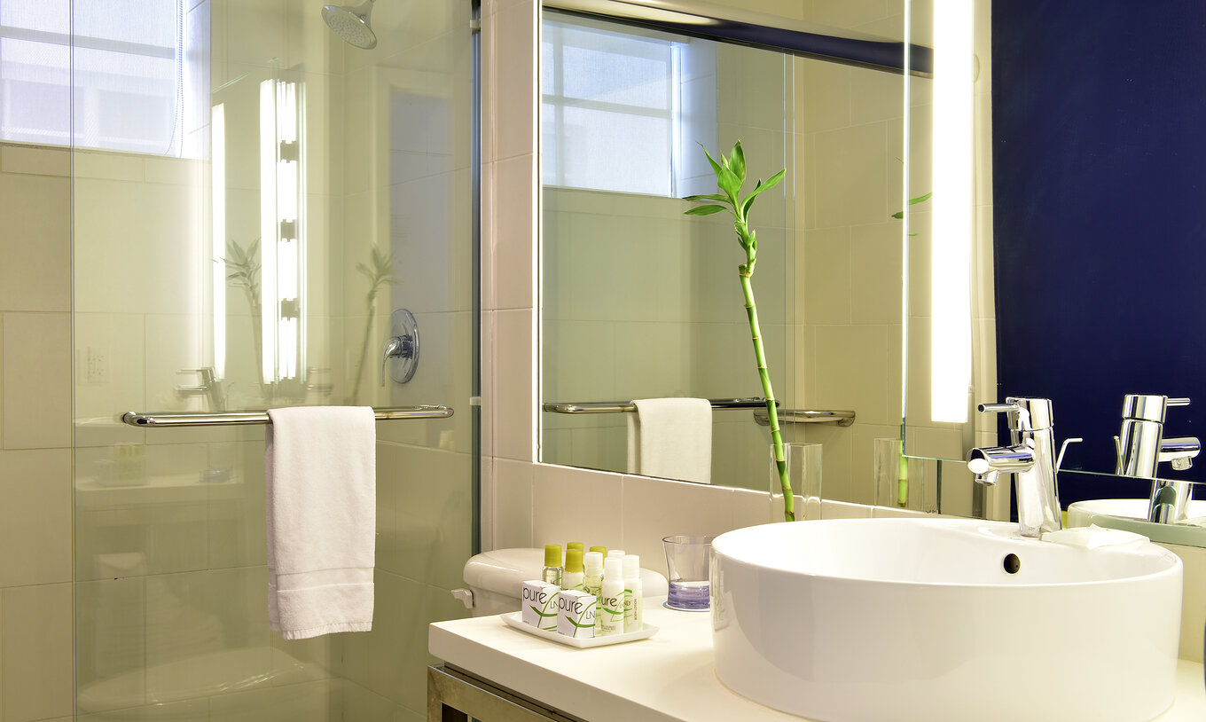 El Quarto Art Deco King - ADA del Pestana Miami South Beach cuenta con lavabo, espejo, toallas y sanitario