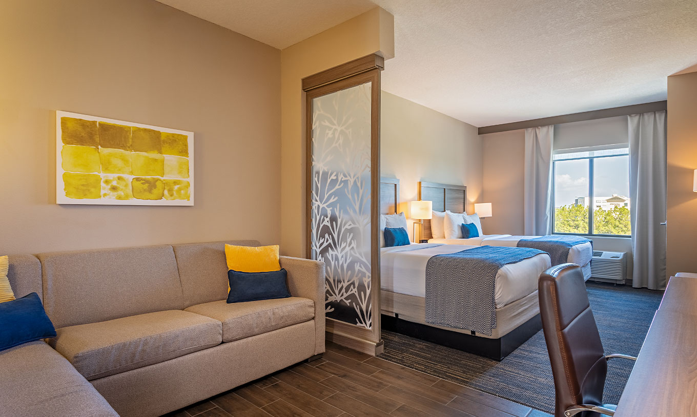 Suite Doble Queen Superior en Pestana Orlando Suites Lake Buena Vista, con sofá, dos camas y ventana amplia