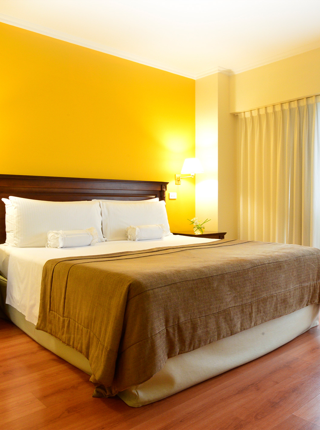 La habitación Queen Deluxe del Pestana Buenos Aires cuenta con una cama de matrimonio y mesita con lámpara