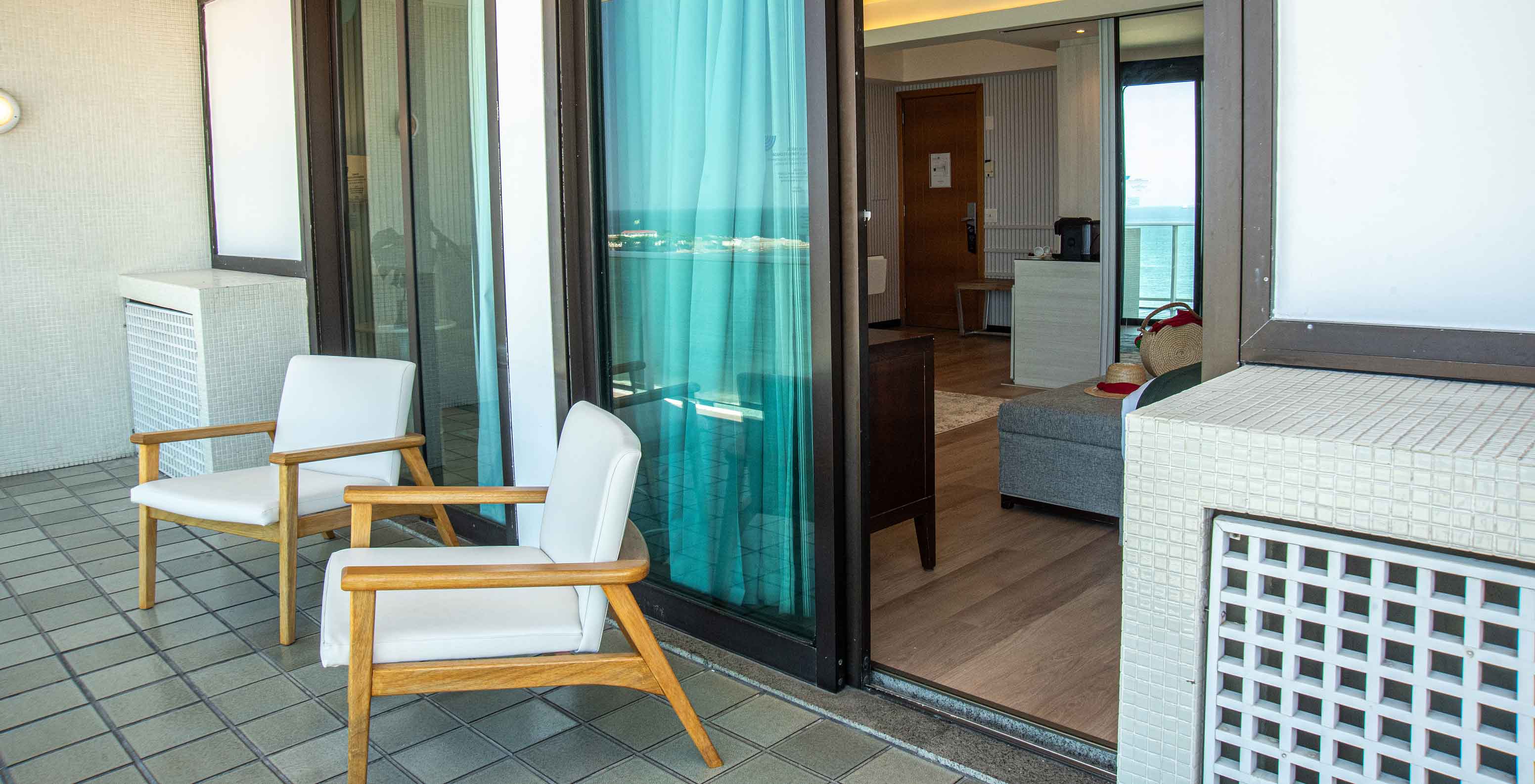 La Suite Oceánica del Pestana Rio Atlântica tiene balcón con sillas y acceso al cuarto.