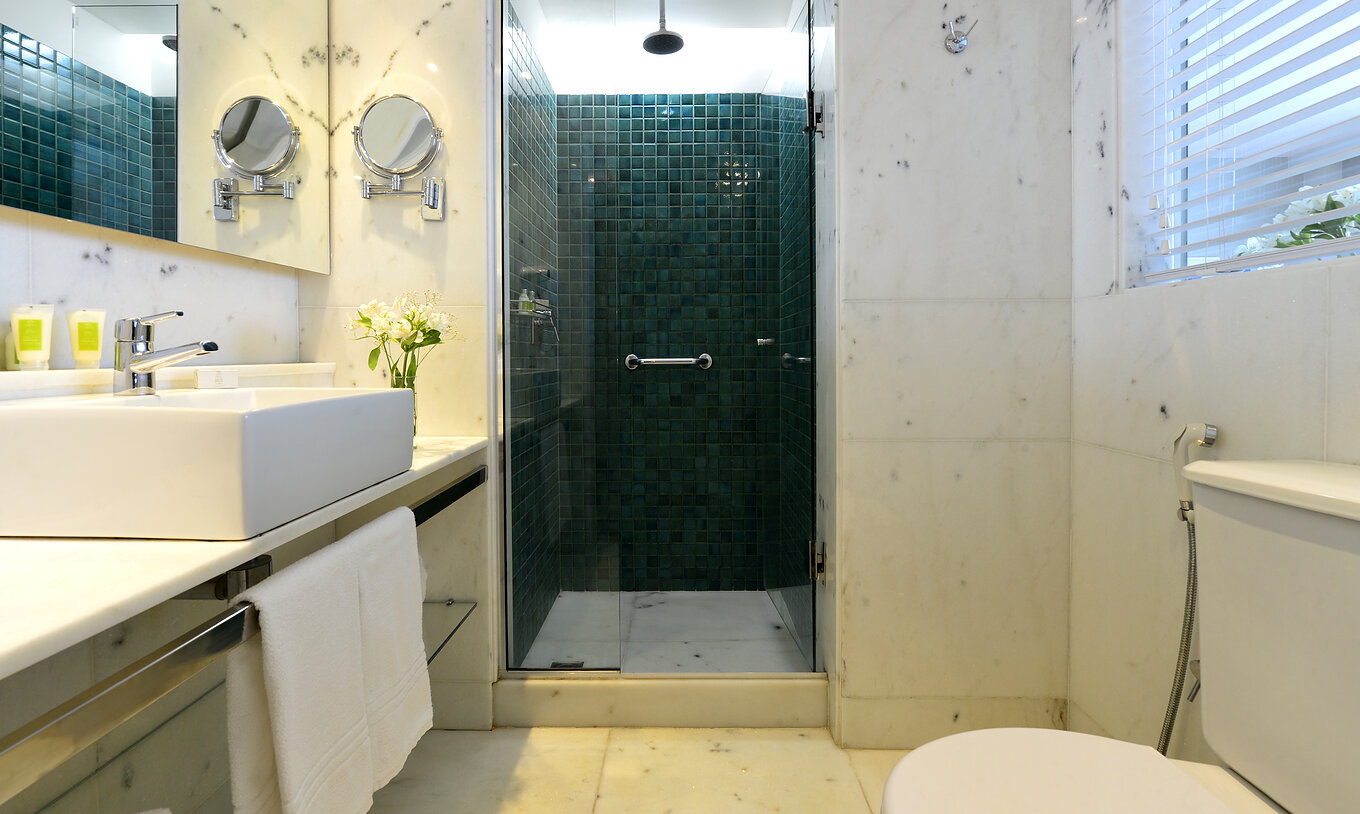 El Twin Con Vista Lateral al Mar del Pestana Rio Atlântica tiene un baño con ducha, inodoro, lavabo y espejo