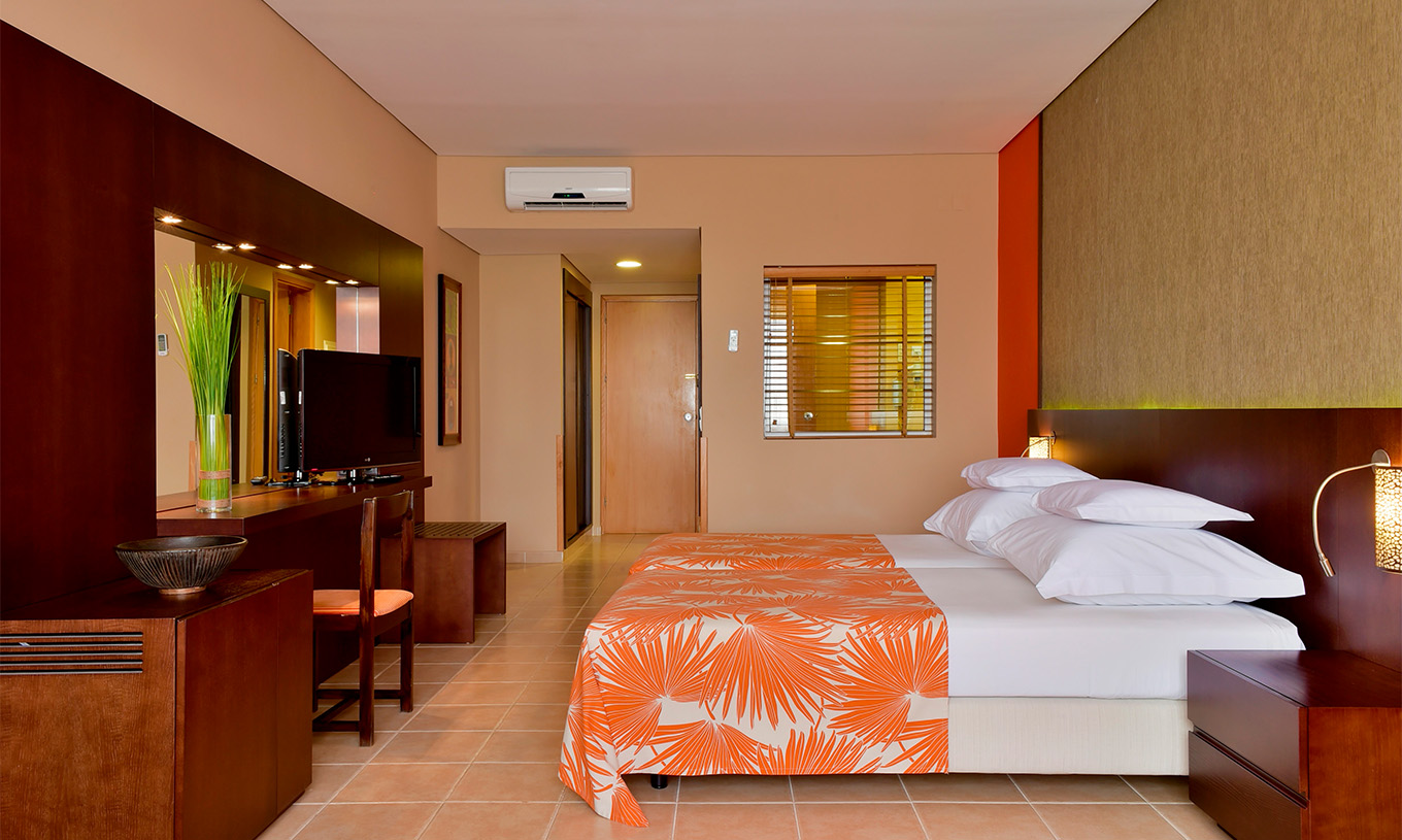 La Habitación Standard del Pestana Tropico cuenta con dos camas, televisión, mesa de cabeceira, espejo y una silla