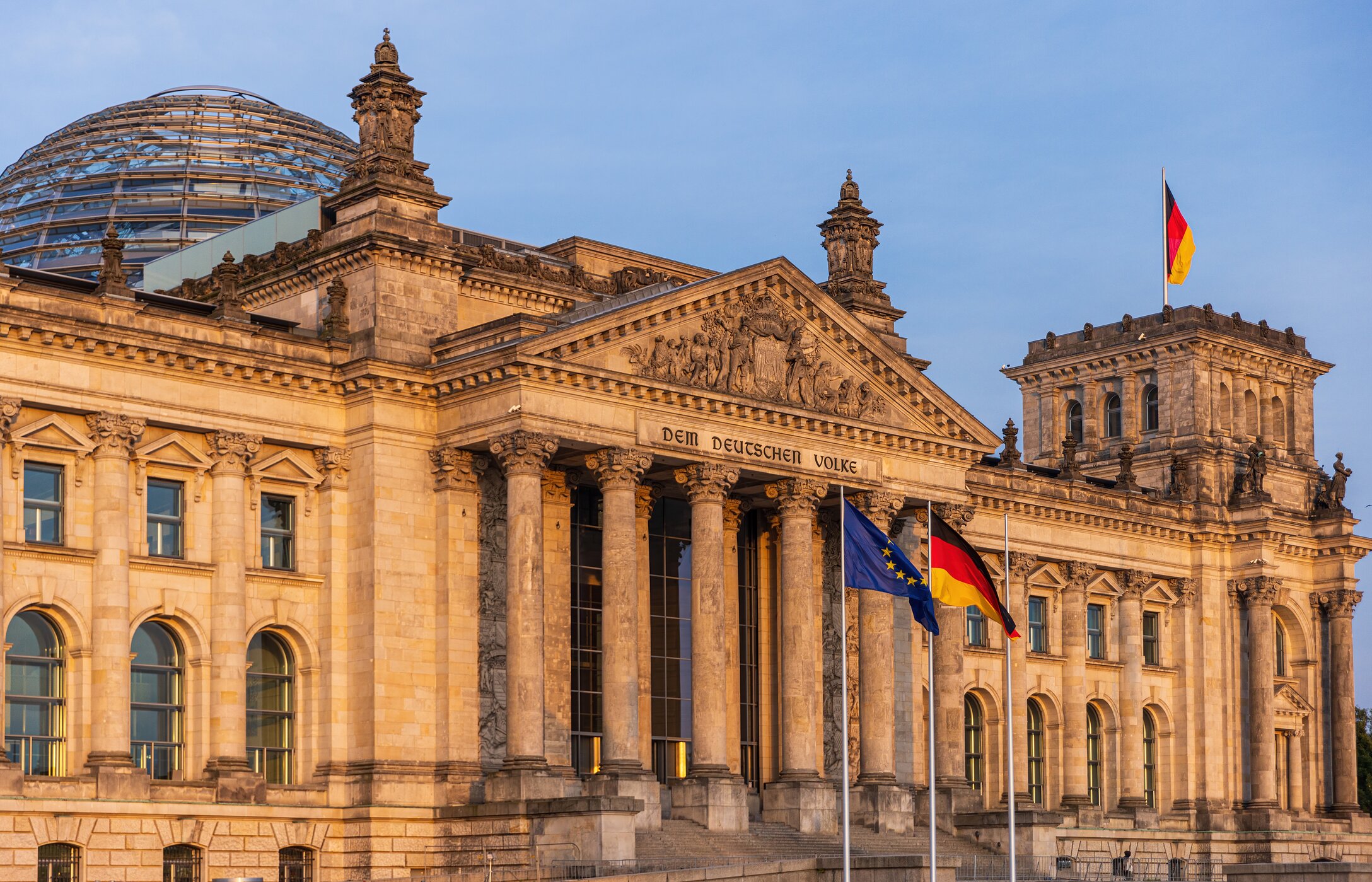 Vista frontal del Reichstag, la sede del parlamento alemán en Berlín, con una cúpula de vidrio y la bandera del país