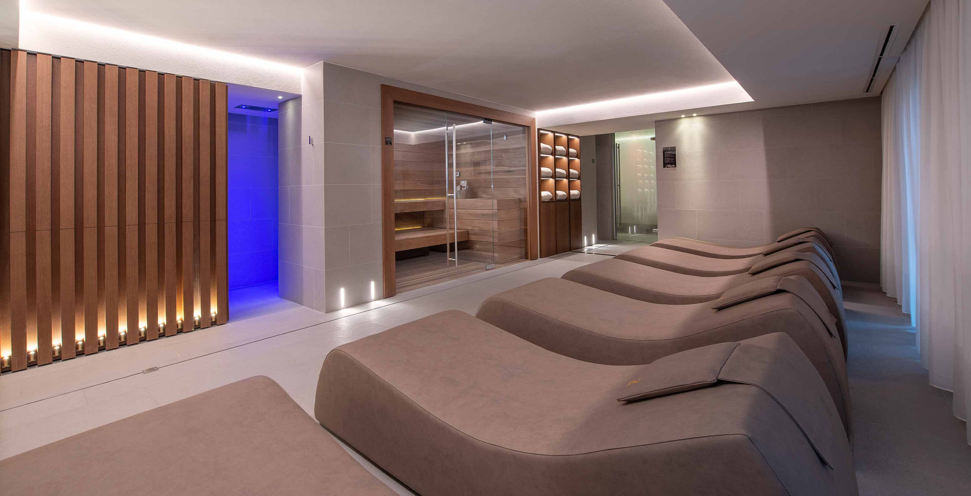 Le Massif Courmayeur, Hotel en los Alpes italianos, con tumbonas de spa junto a sauna iluminada de madera