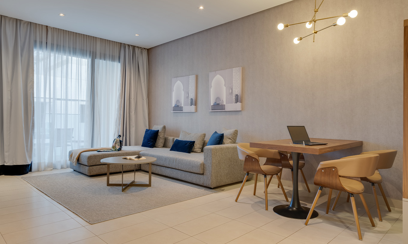 Suite Familiar Premium con vistas laterales al océano en Pestana Casablanca con sofá, mesa y ventanales