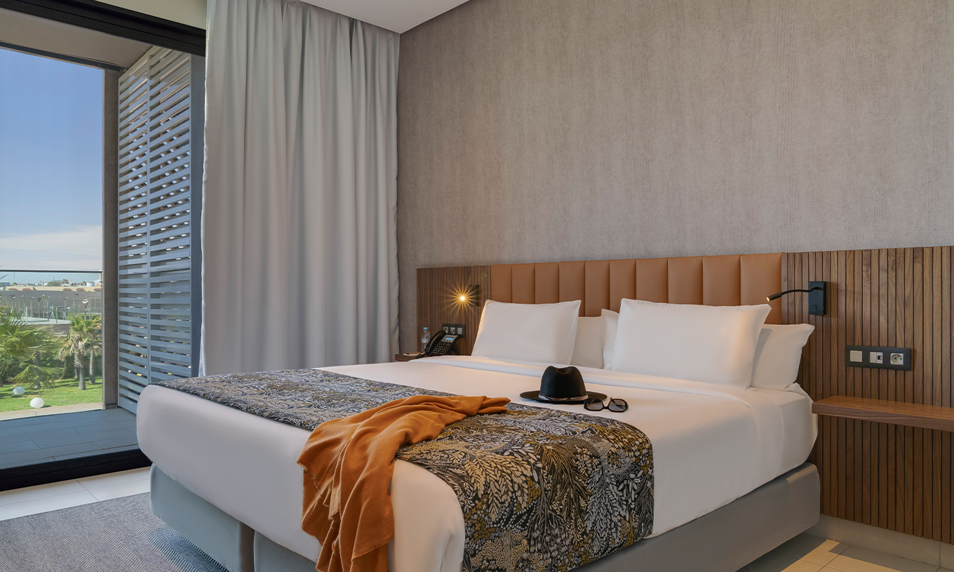 Suite Premium con vistas laterales al océano en Pestana Casablanca con cama doble y ventanal luminoso
