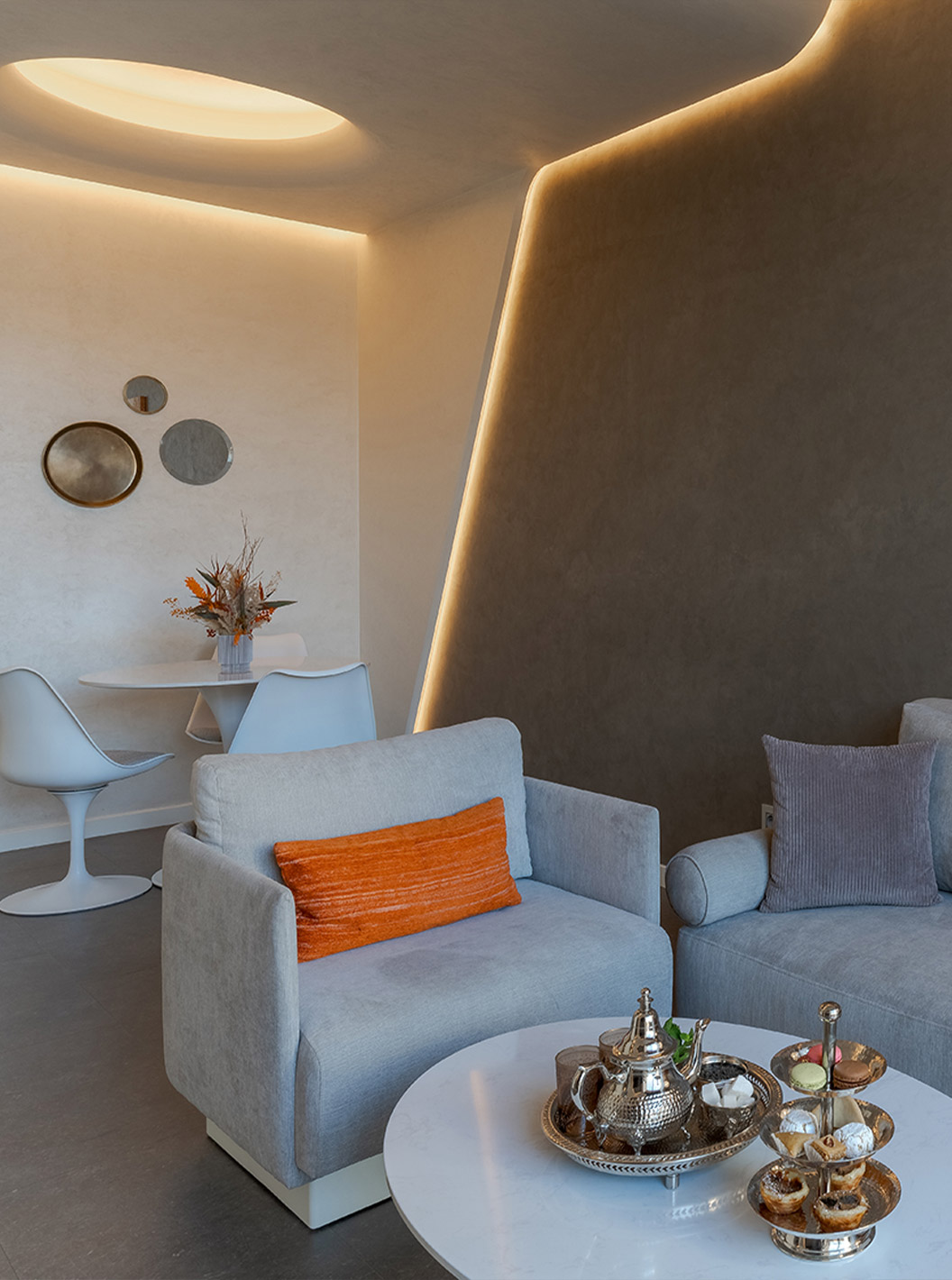 Suite CR7 en Pestana CR7 Marrakech con sofá claro, mesa redonda y rincón comedor con iluminación tenue