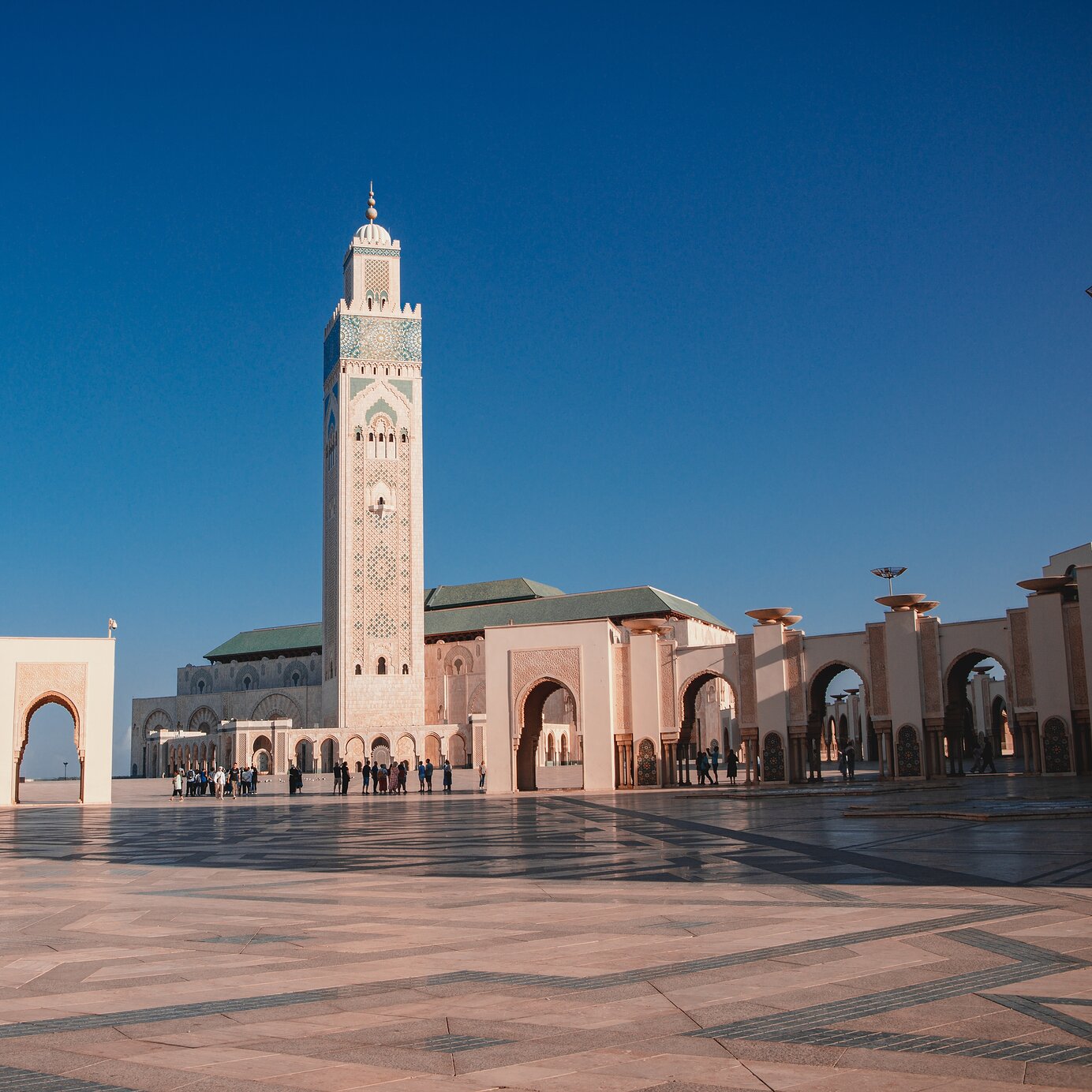 Casablanca, Marruecos Hospédese en un hotel Pestana y explore la Mezquita Hassan II en Casablanca, Marruecos, con una gran plaza al frente.