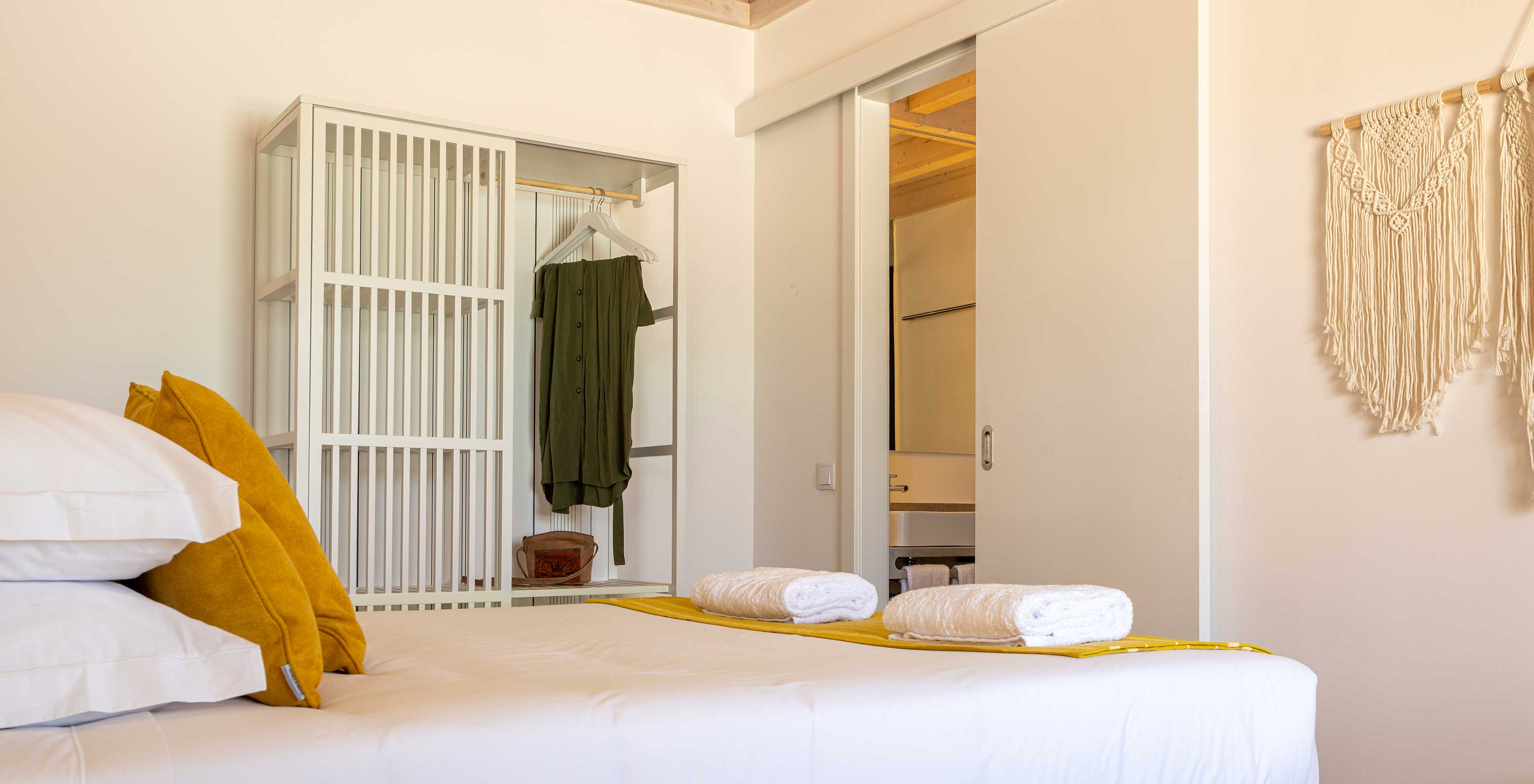 La Premium Villa de Pestana Comporta Village Residences tiene un dormitorio minimalista con cama y banco