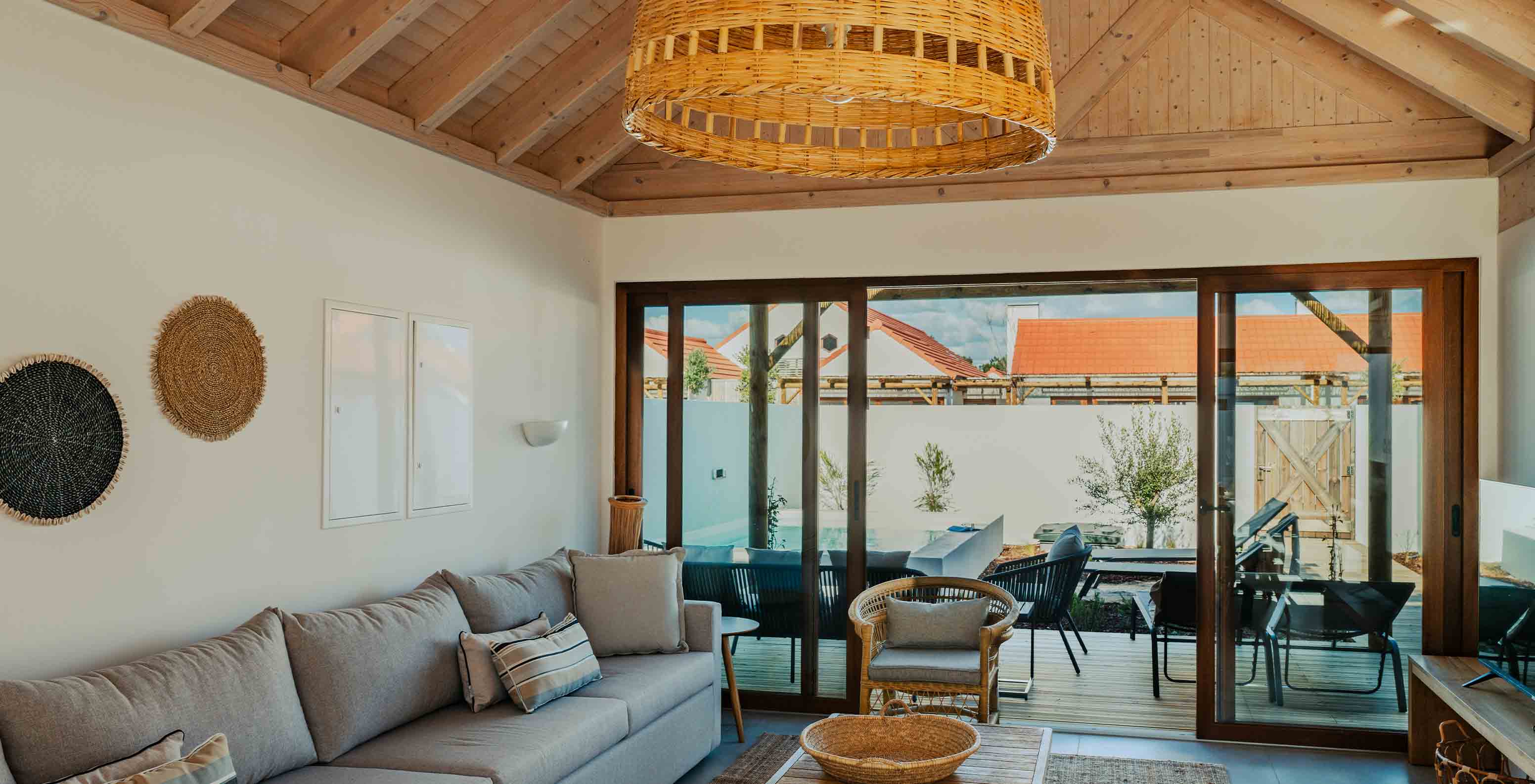 La Superior Villa de Pestana Comporta Village Residences tiene una sala de estar con sofá gris y balcón al fondo