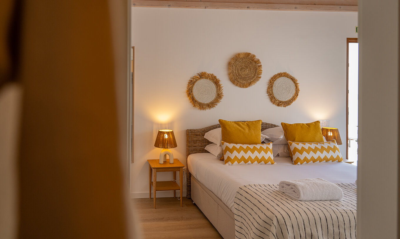 La Superior Villa de Pestana Comporta Village Residences tiene un dormitorio con cama doble y almohadas amarillas