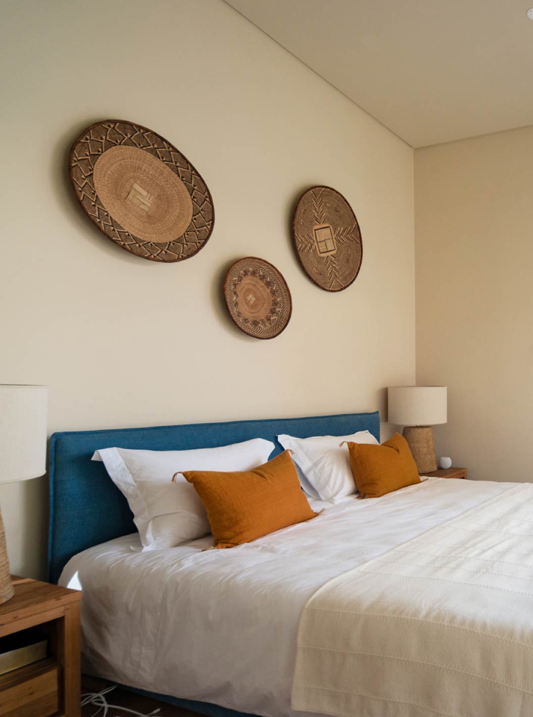 La villa exclusiva con piscina del Pestana Tróia Eco Resort tiene una cama doble con cojines naranjas frente a una ventana