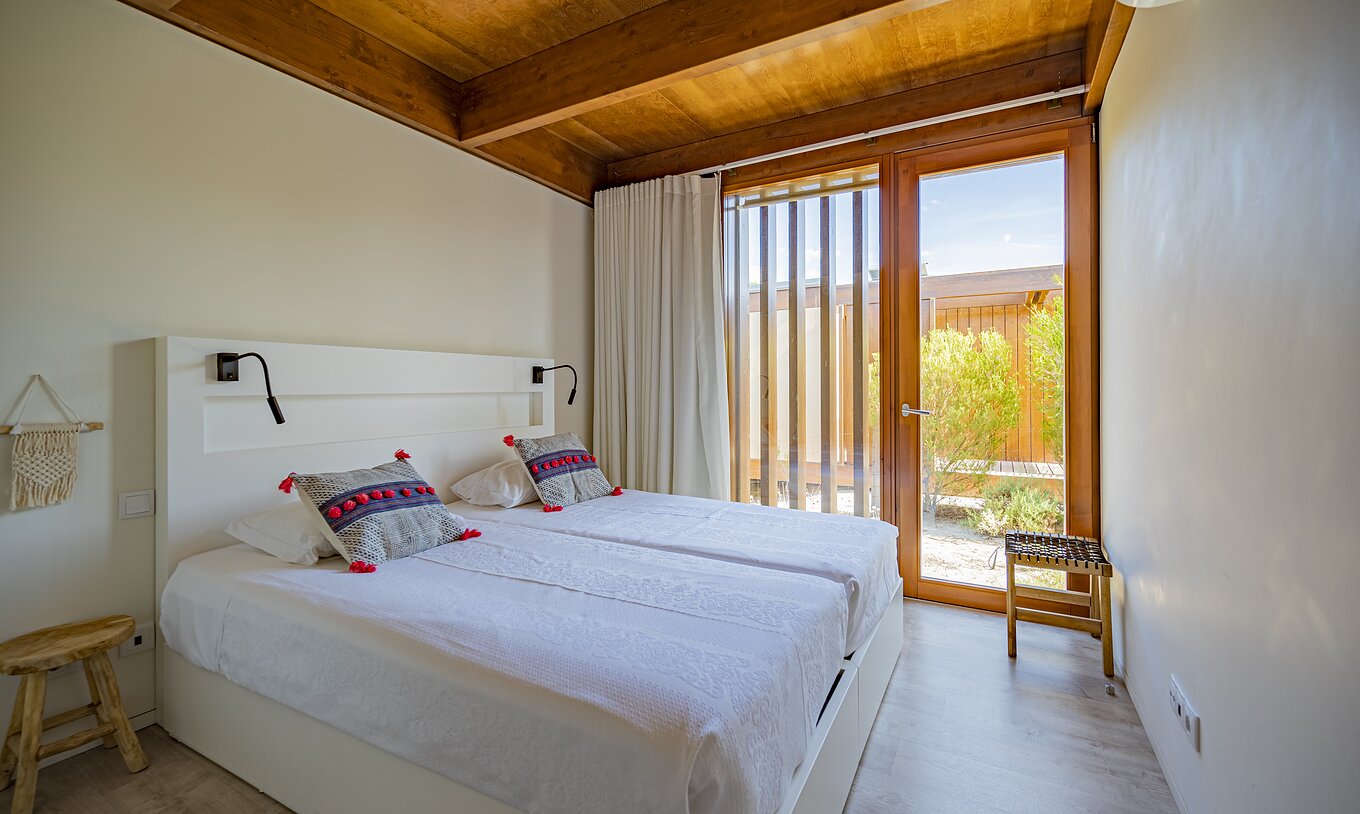 La Tree Villa con Piscina Privada del Pestana Tróia Eco Resort tiene una cama de matrimonio y una ventana de arriba a abajo