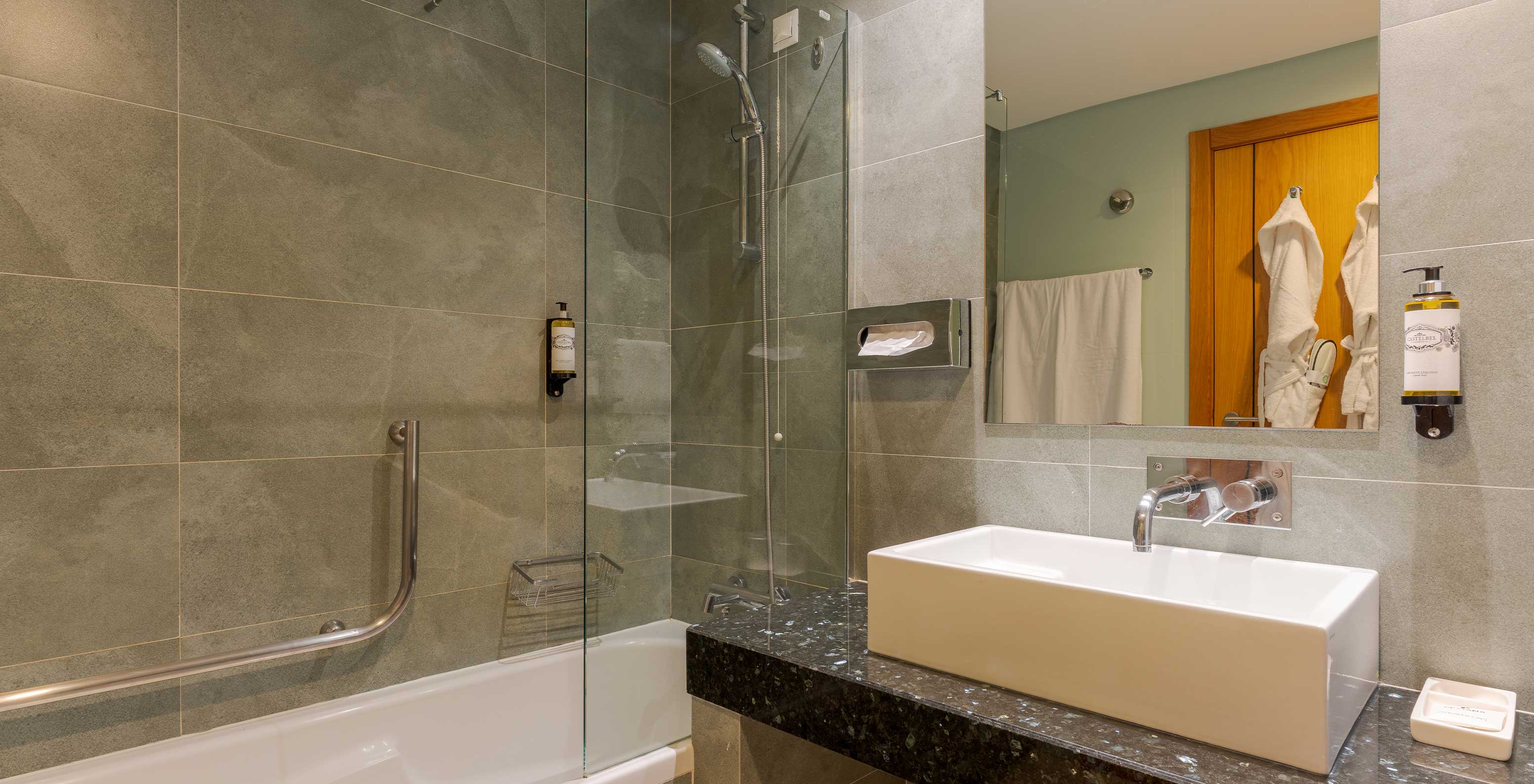 El Apartamento T1 Vista Jardín del Pestana Alvor Beach Villas tiene baño con lavabo, espejo y bañera con ducha