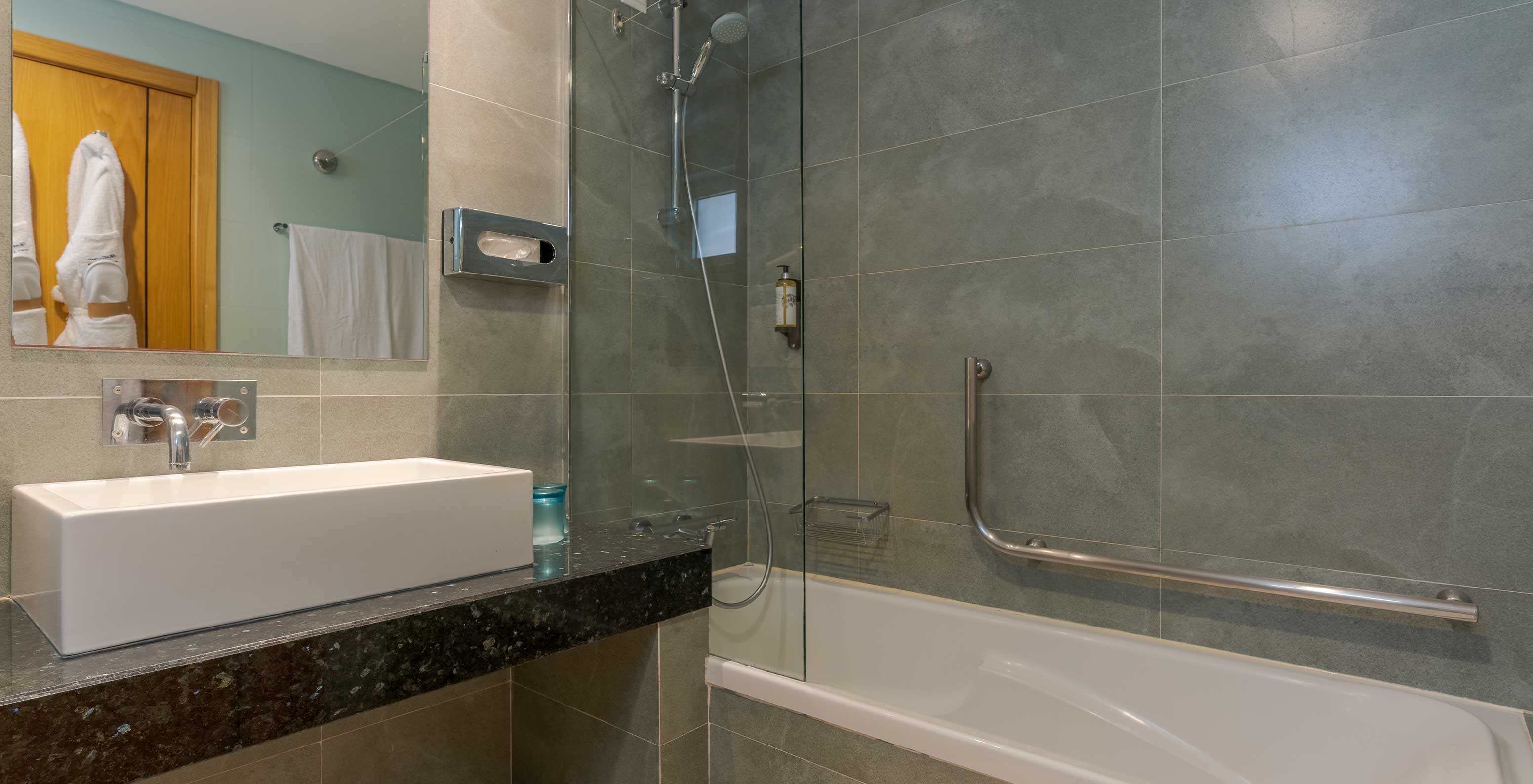 El Estudio Vista Jardín del Pestana Alvor Beach Villas tiene baño con bañera, ducha y lavabo con espejo