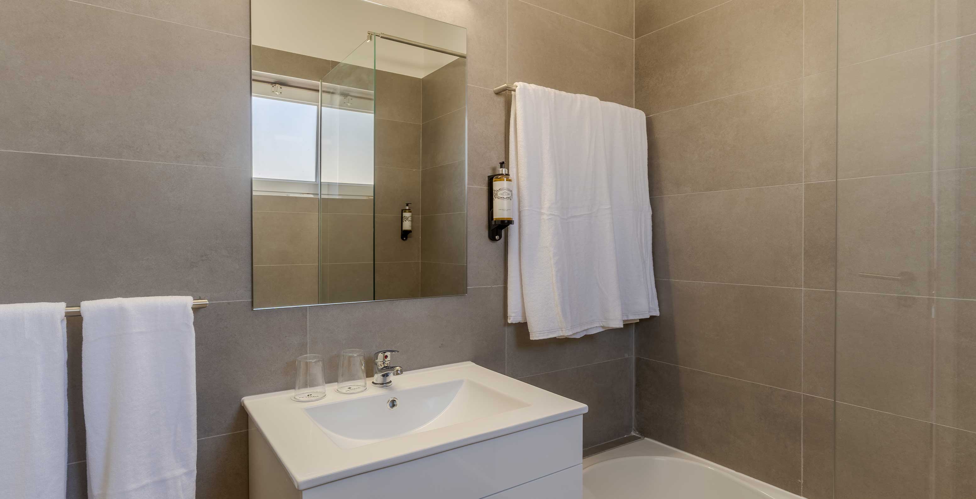 La Villa 3 Habitaciones Premium Vista Mar del Pestana Alvor Beach Villas tiene baño con lavabo, espejo y toalla