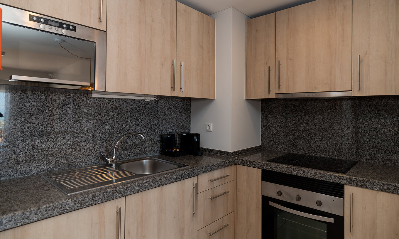 Apartamento T1 Vista Mar en Pestana Alvor Beach Villas tiene cocina equipada con fogón, microondas y armarios