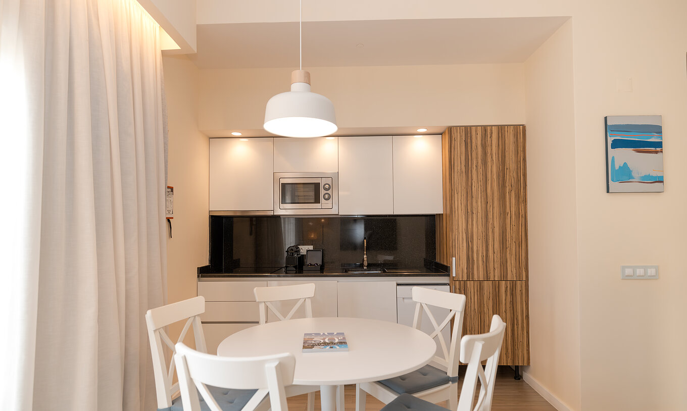 Villa 2 Habitaciones Superior Vista Jardín en Pestana Alvor Beach Villas tiene mesa de comedor y cocina equipada