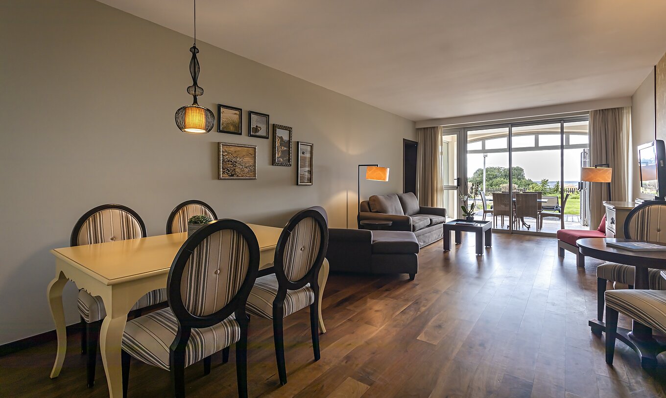 La Cliff Suite T2 en Pestana Alvor Praia tiene una sala de estar con dos sofás, una televisión, una mesa de comedor y porche