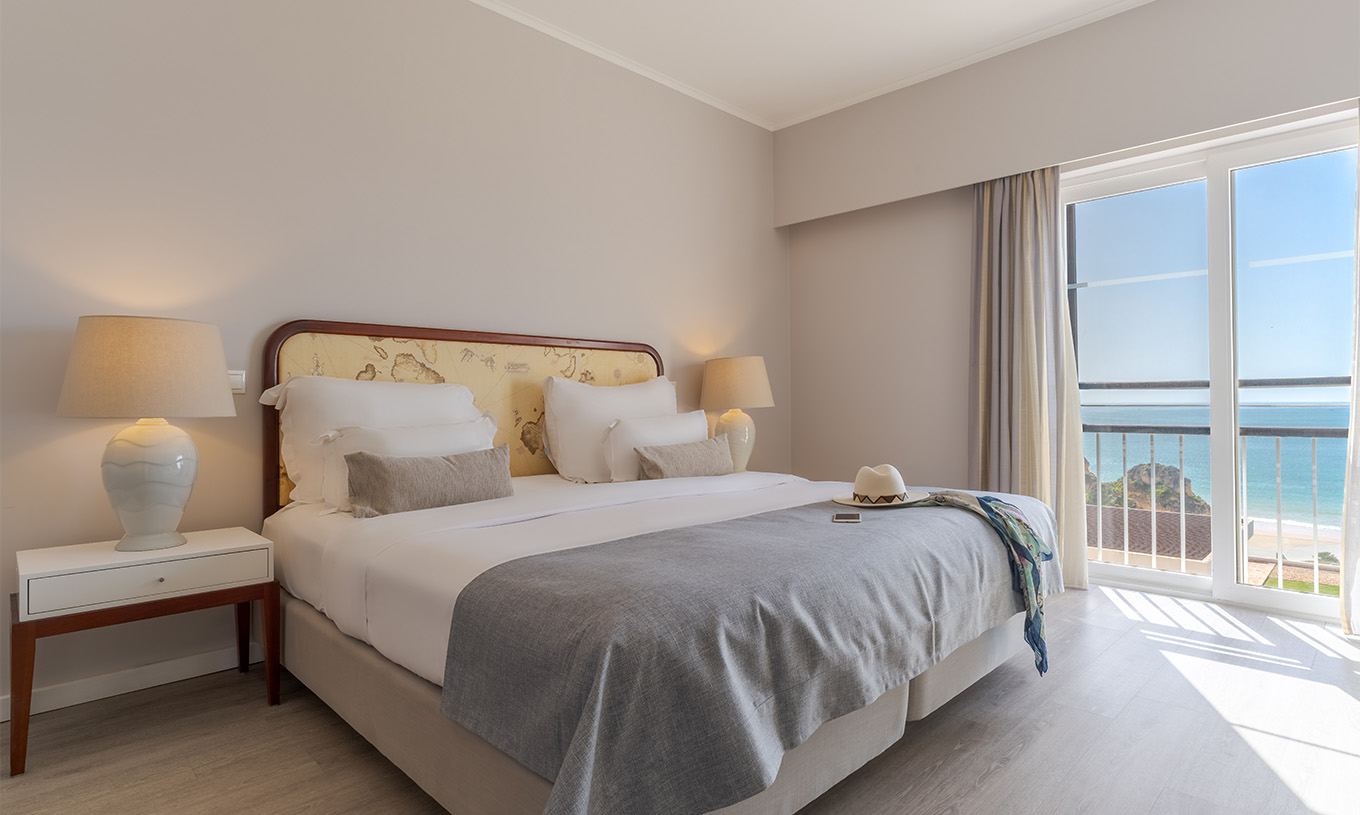 La Suite Luxo Vista Mar del Pestana Alvor Praia tiene cama matrimonial, mesa de noche con lámpara y ventanas con vista mar