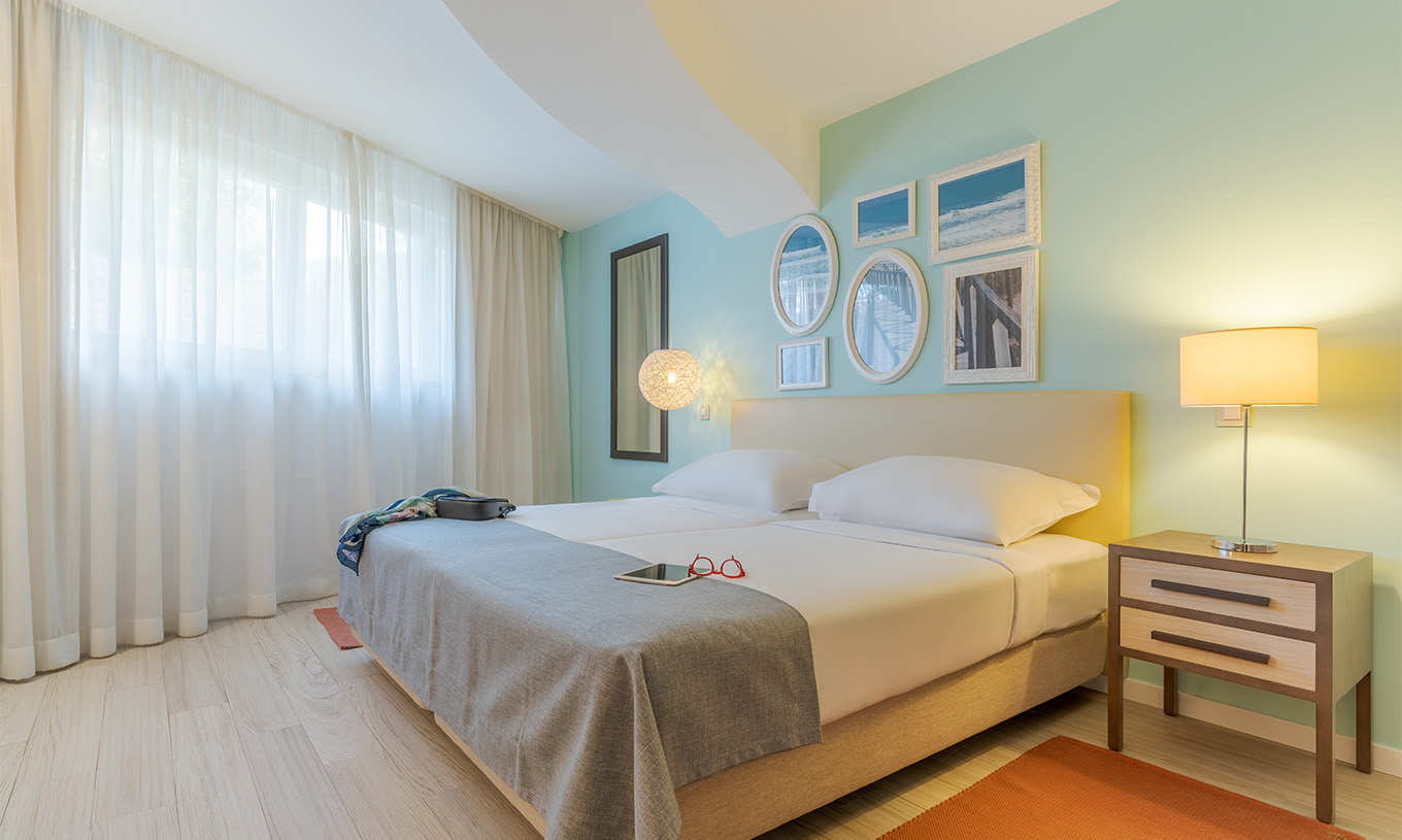 La Suite T1 Duplex Vista Mar del Pestana Alvor Praia tiene dos camas juntas, mesa de noche con lámpara, alfombra y cuadros