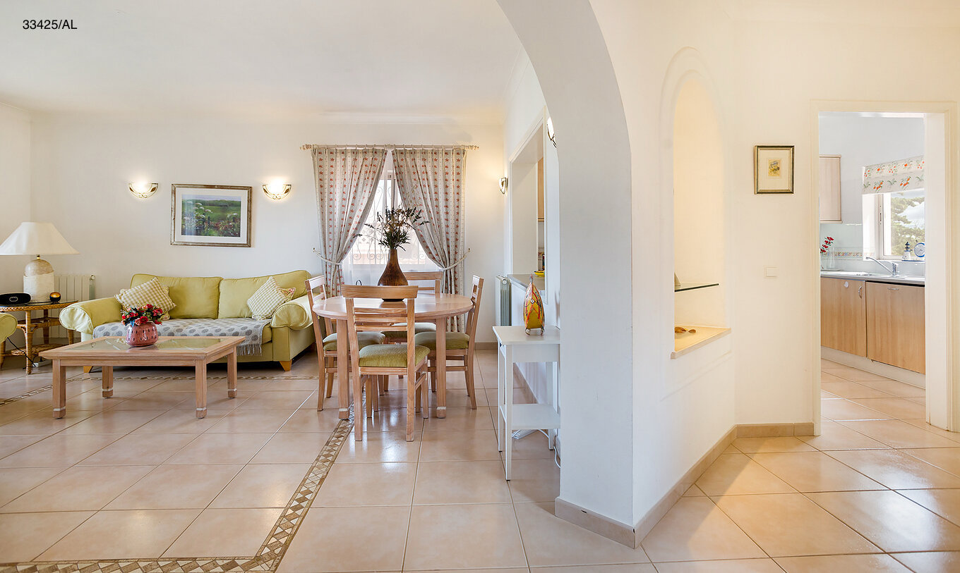 El apartamento Pestana Carvoeiro Golf T2 Estándar tiene una sala de estar con sofá verde y una mesa con sillas