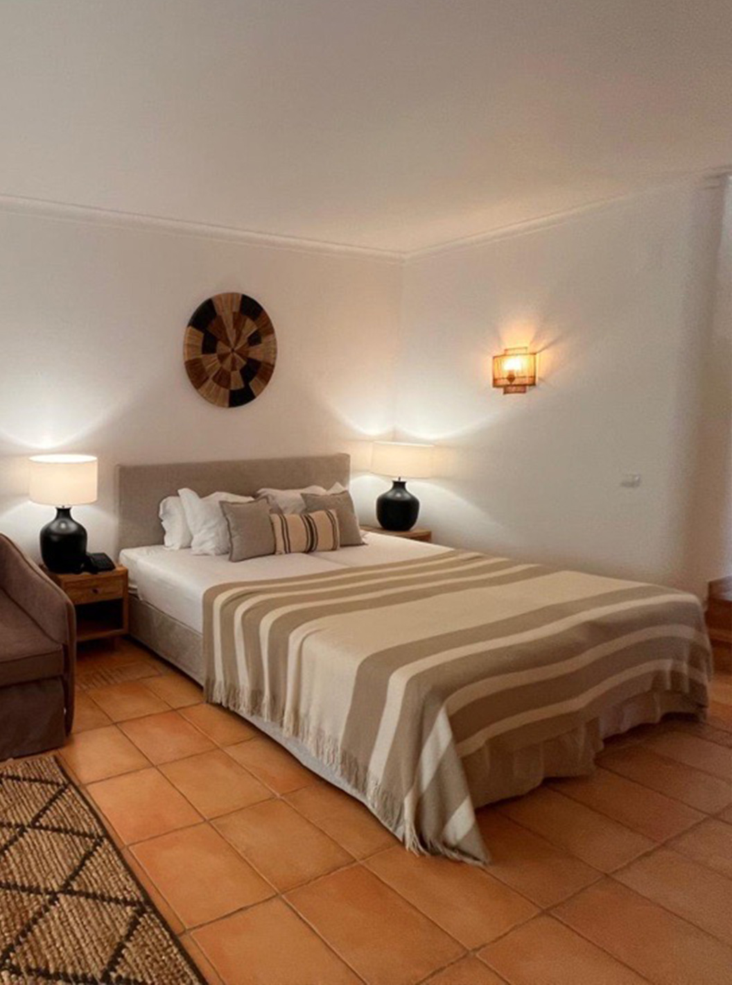 Estudio en Pestana Palm Gardens con cama doble, sofá marrón, lámparas cálidas y decoración de pared tejida