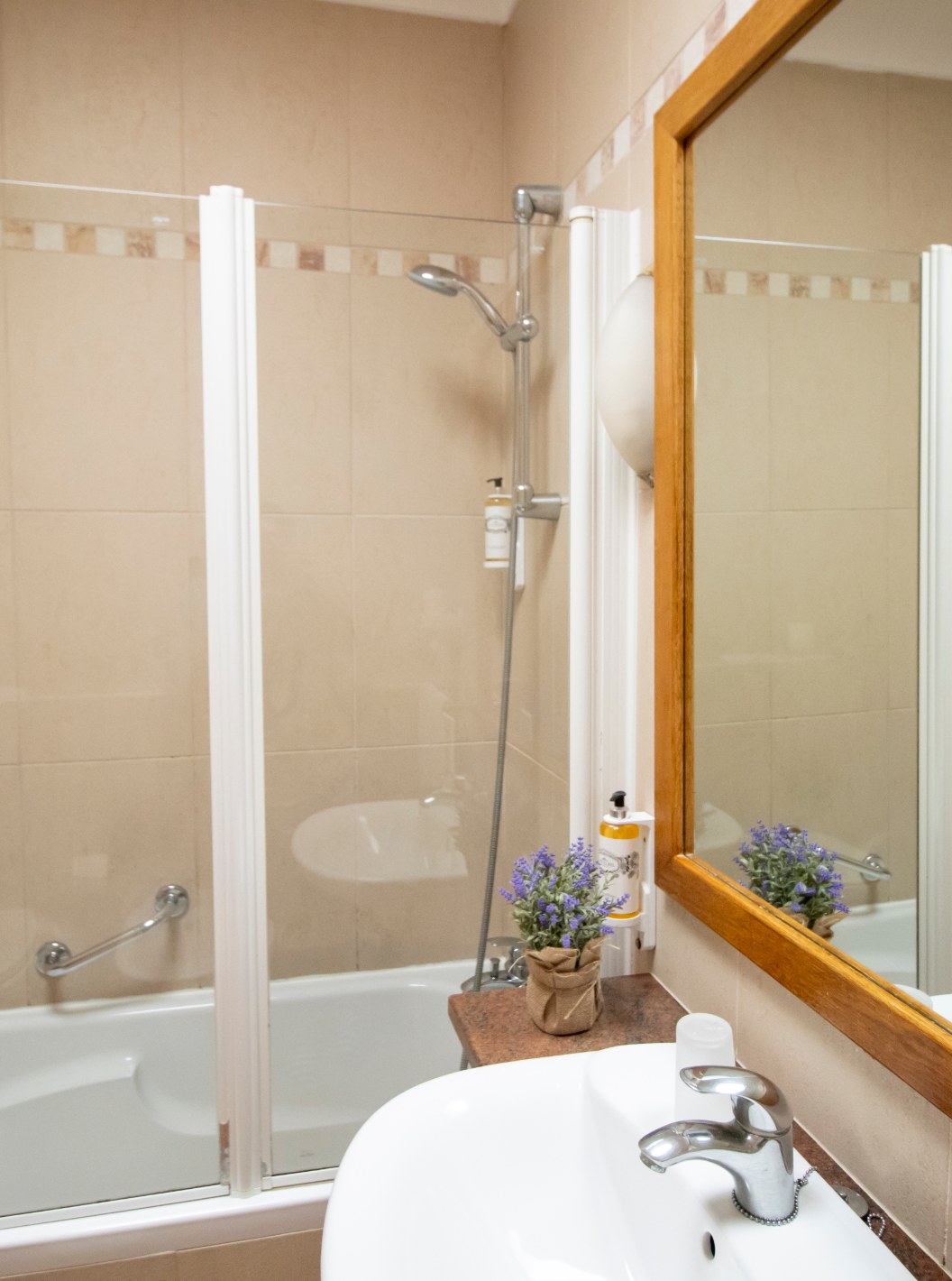 Apartamento T1 Superior de Pestana Palm Gardens con baño beige, bañera con mampara y lavabo con espejo
