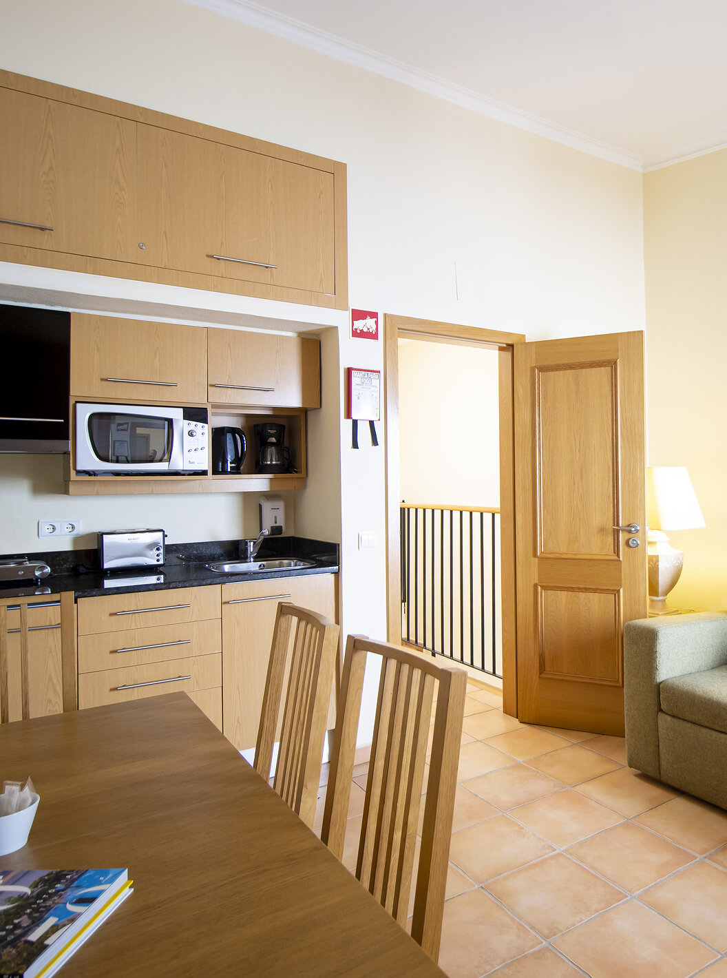 El Apartamento T1 - Terra del Pestana Palm Gardens tiene una sala de estar con sofá, mesa y kitchenette con microondas