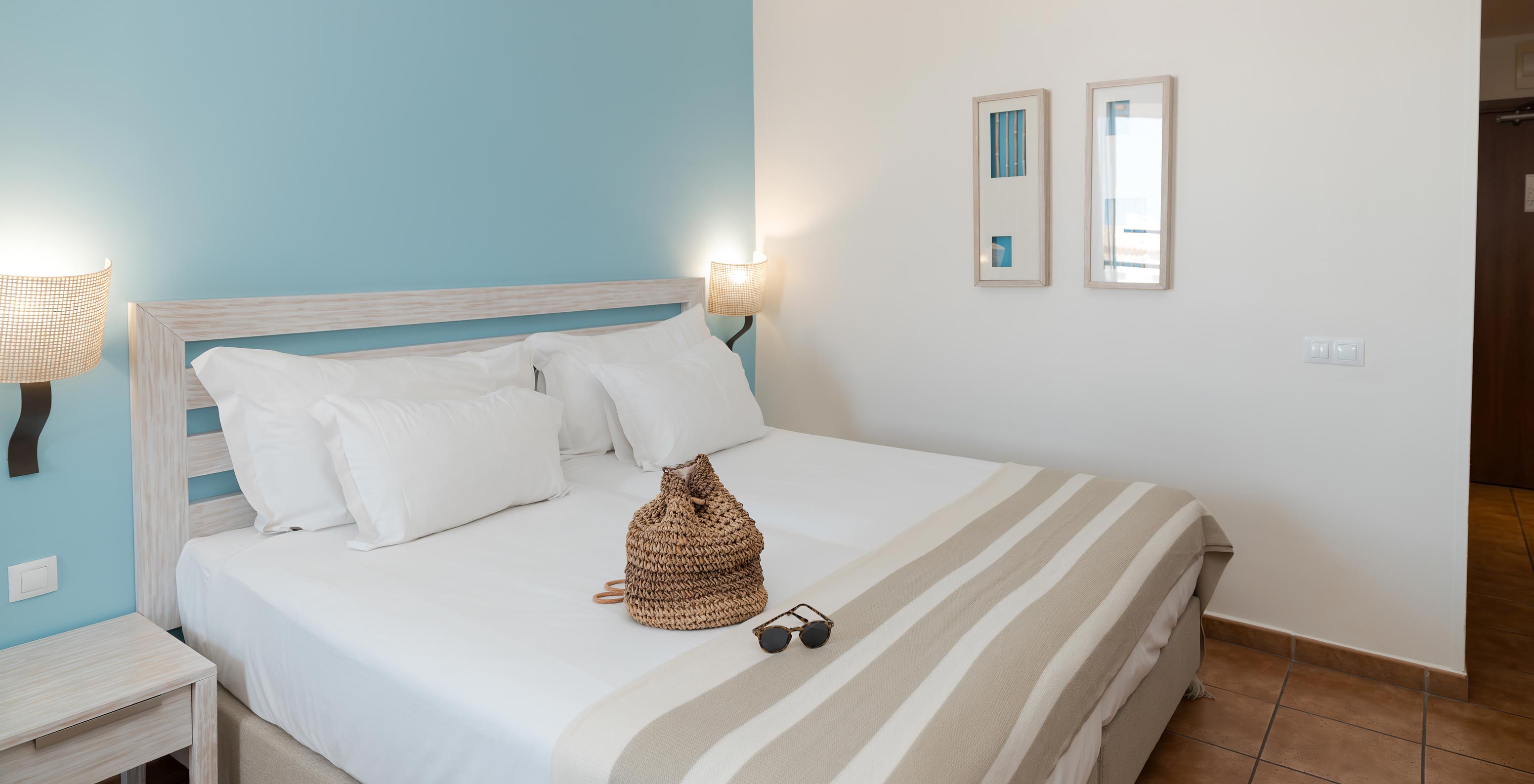 El Deluxe Vista Mar Lateral del Pestana Viking tiene dos camas, mesas de noche y dos cuadros en la pared