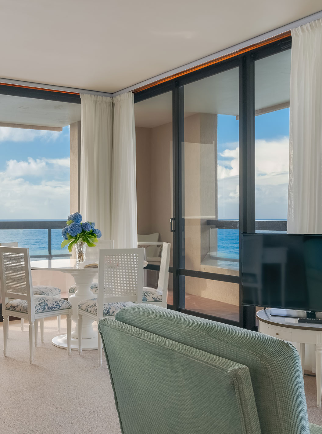 La Suite del Pestana Bahia Praia tiene sala de estar con escritorio, mesa y sofá con televisión, con vista al mar