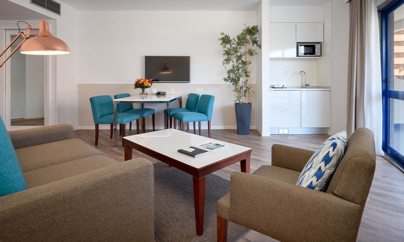 La Suite Deluxe del Pestana Cascais cuenta con sala de estar, sofá, mesa de centro, mesa de comedor y televisión