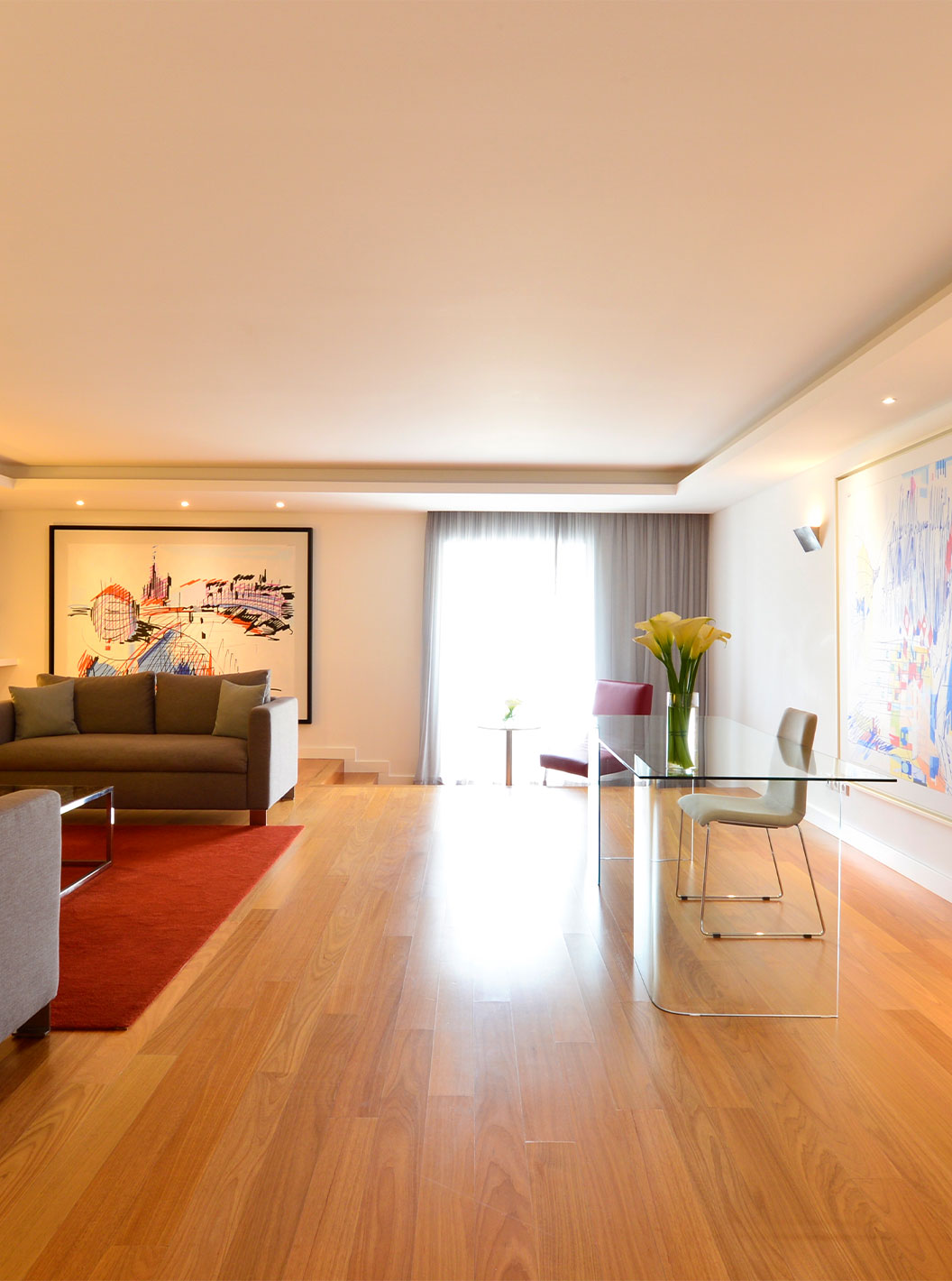 La Suite Presidencial del Pestana Cidadela Cascais tiene una sala con un escritorio transparente y silla, cuadros y un sofá