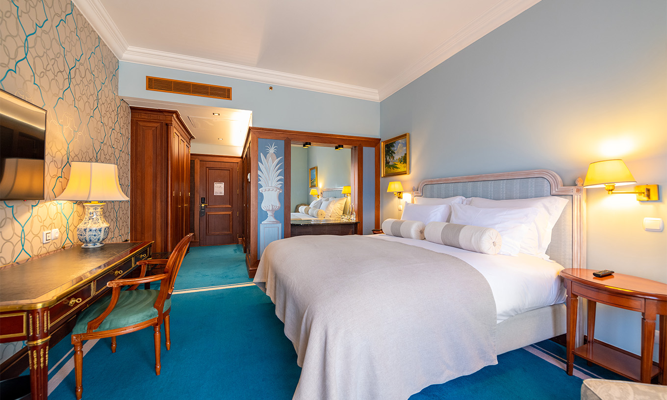 El Premium Balcony del Pestana Palace Lisboa tiene una cama, paredes revestidas de madera con un espejo y armarios