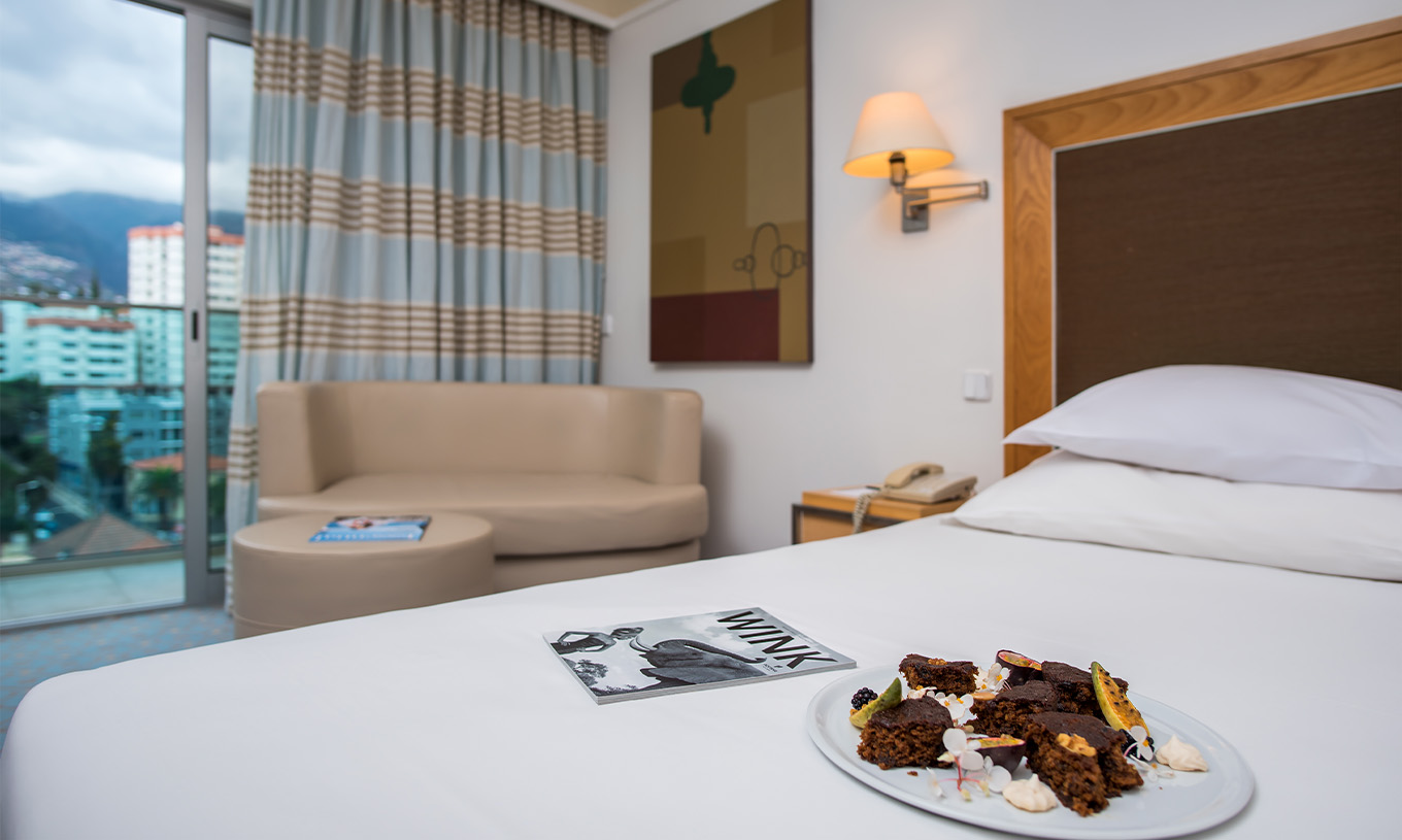 La Suite del Pestana Carlton Madeira tiene cama, con un plato de chocolate y fruta