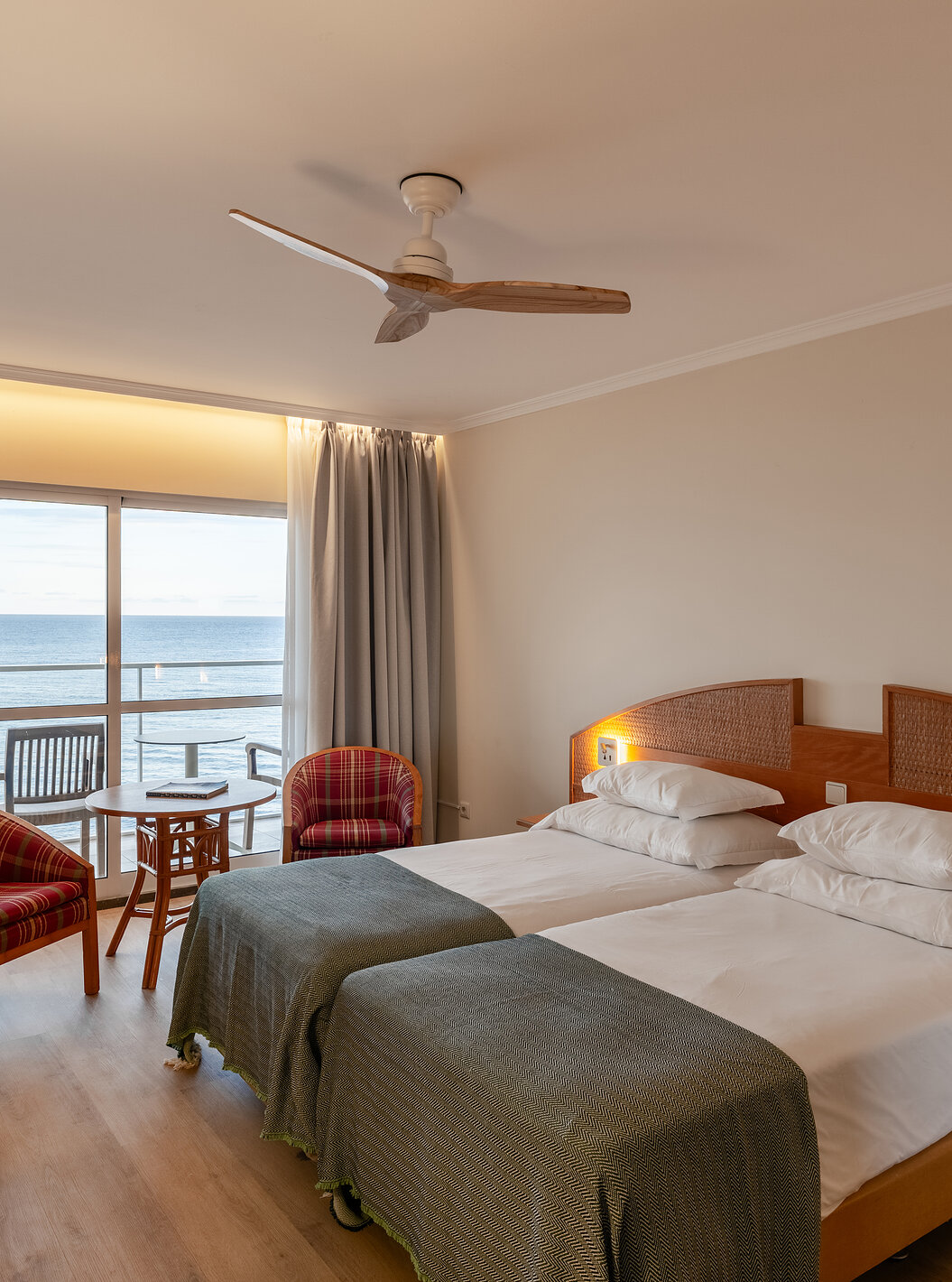 El Superior Sea View del Pestana Ocean Bay All Inclusive tiene una cama doble con una colcha verde y balcón con vistas al mar