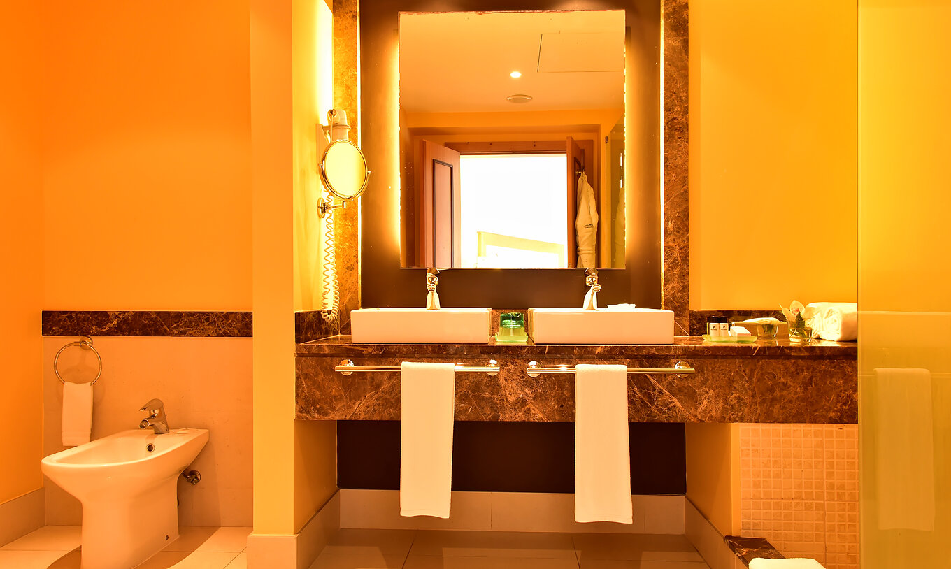 La Suite del Pestana Promenade tiene un baño con un espejo con marco marrón, dos lavabos y bidé