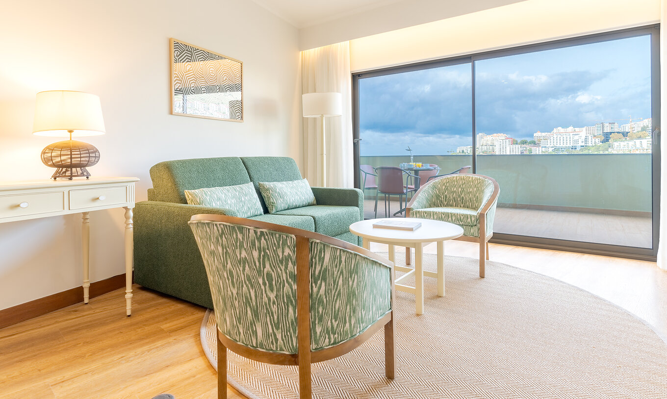 La Suite Superior Vista Mar Lateral del Pestana Vila Lido Madeira tiene una sala de estar con sofá, sillones y balcón