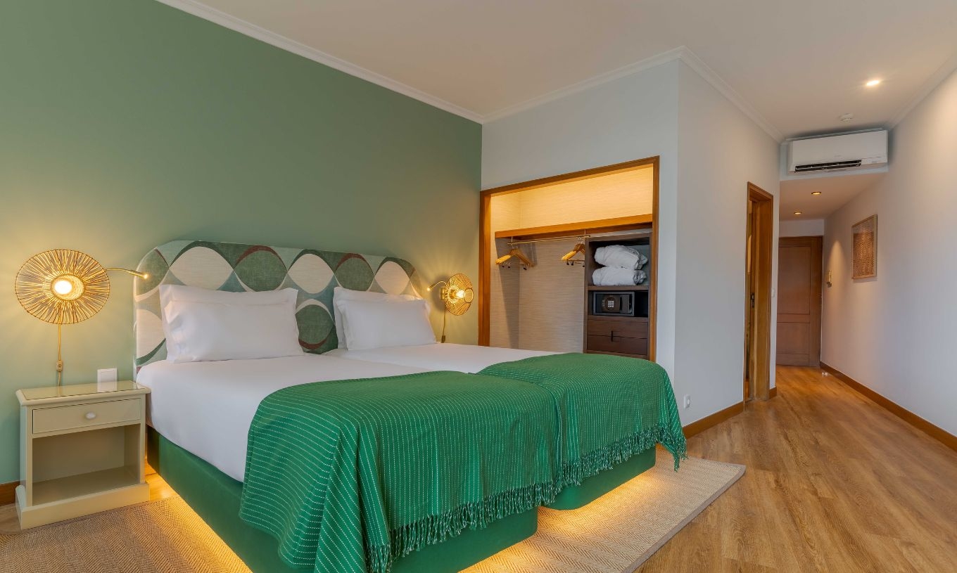 La habitación Superior Side Sea View del Pestana Vila Lido Madeira tiene cama doble con cabecero verde y armario.
