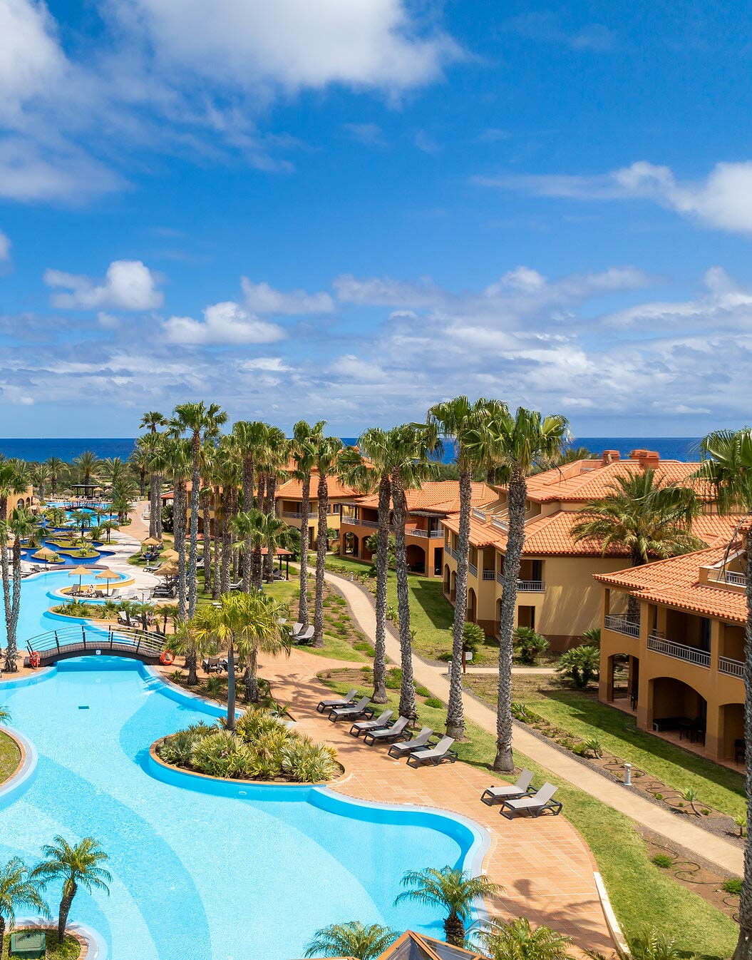 Vista del resort de 5 estrellas en Porto Santo, rodeado de palmeras tropicales y jardines.