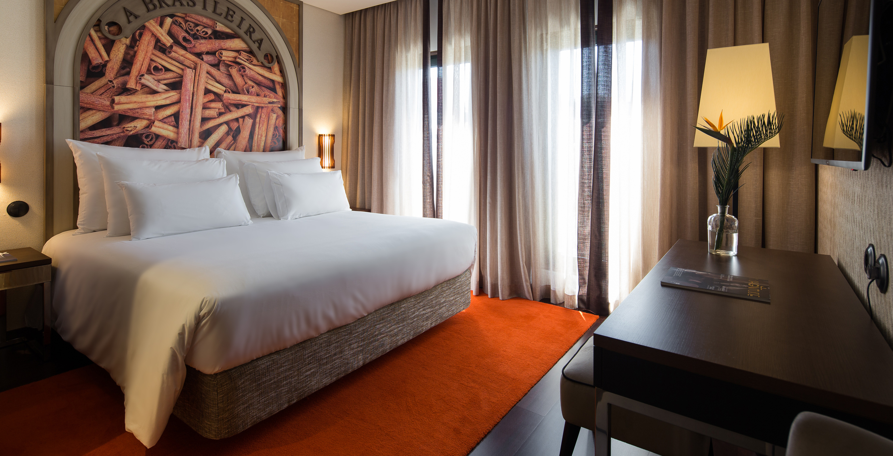 El Deluxe Executive Grand View del Pestana Porto - A Brasileira tiene una cama king size con un mural temático sobre canela
