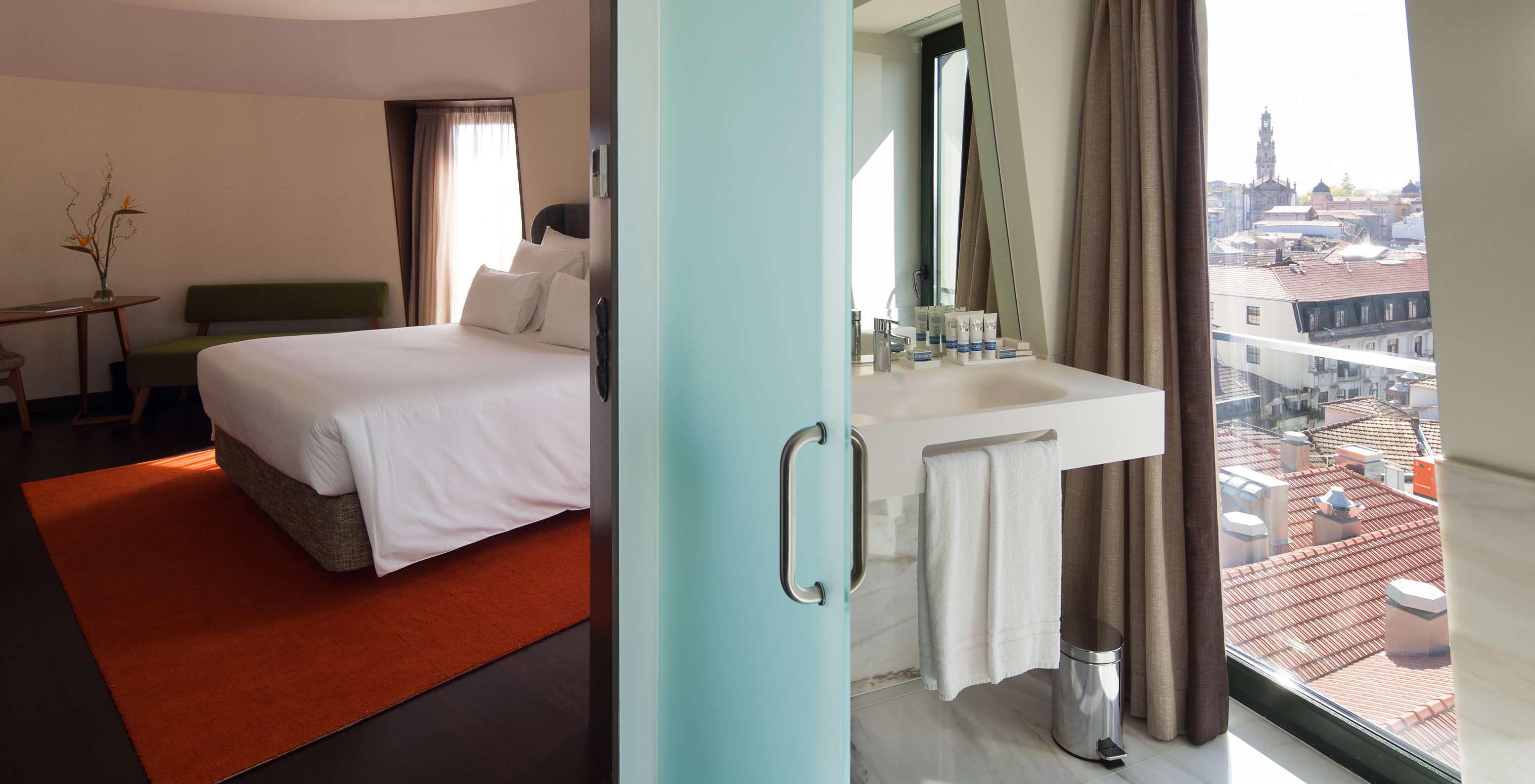 Habitación Signature View con vista panorámica en Pestana A Brasileira Porto, dormitorio y baño con vistas urbanas