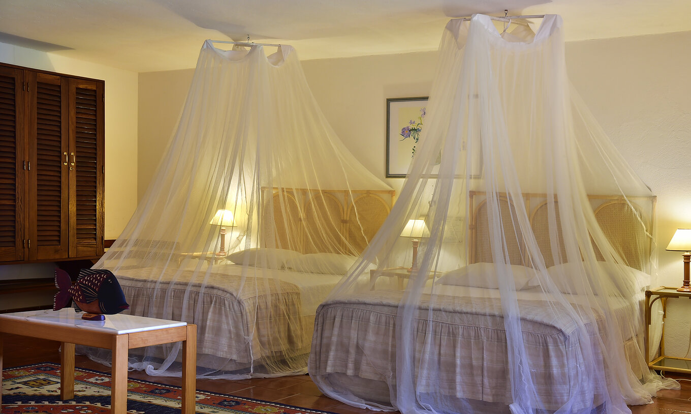 El Classic del Pestana Miramar São Tomé tiene dos camas matrimoniales con mosquitero y tres mesas de noche