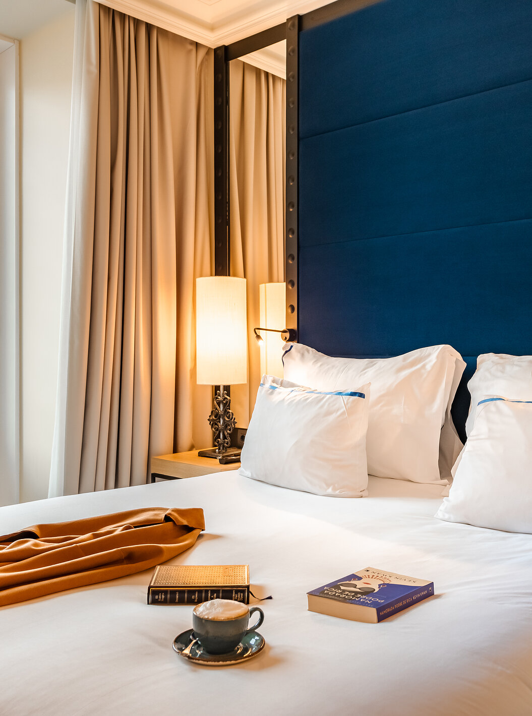 El Superior Plaza Mayor del Pestana Plaza Mayor Madrid tiene una cama con cabecera azul con espejo y una ventana grande