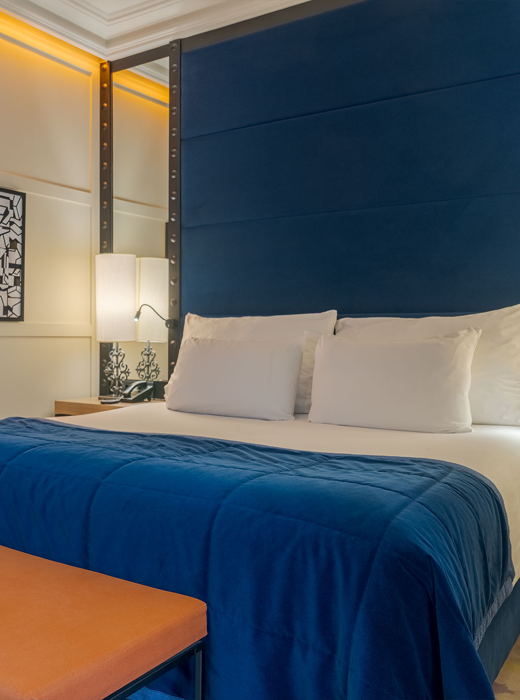 Habitación Superior en Pestana Collection Plaza Mayor con cama doble, televisor y cabecero azul iluminado