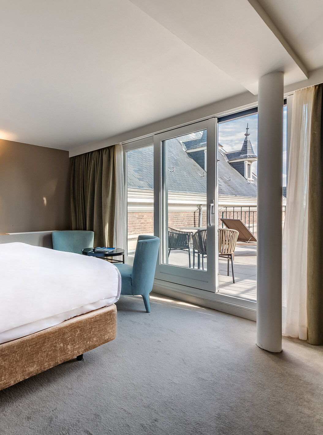 El cuarto Executive Terrace del Pestana Amsterdam Riverside tiene una cama doble con vista al balcón, y dos sillones