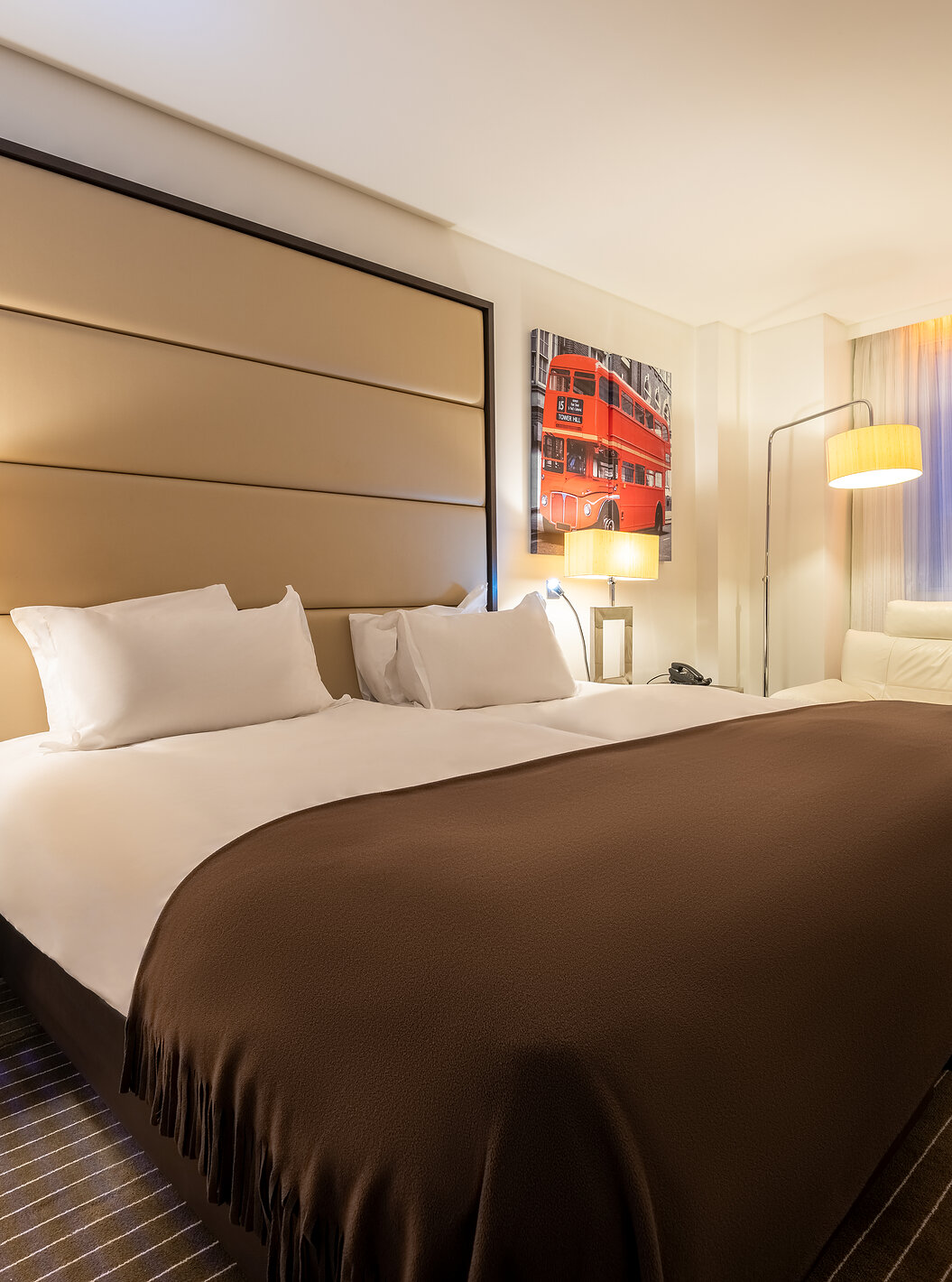 El Premium Twin del Pestana Chelsea Bridge tiene dos camas juntas, mesa de noche, sofá, lámparas y ventanas con cortinas